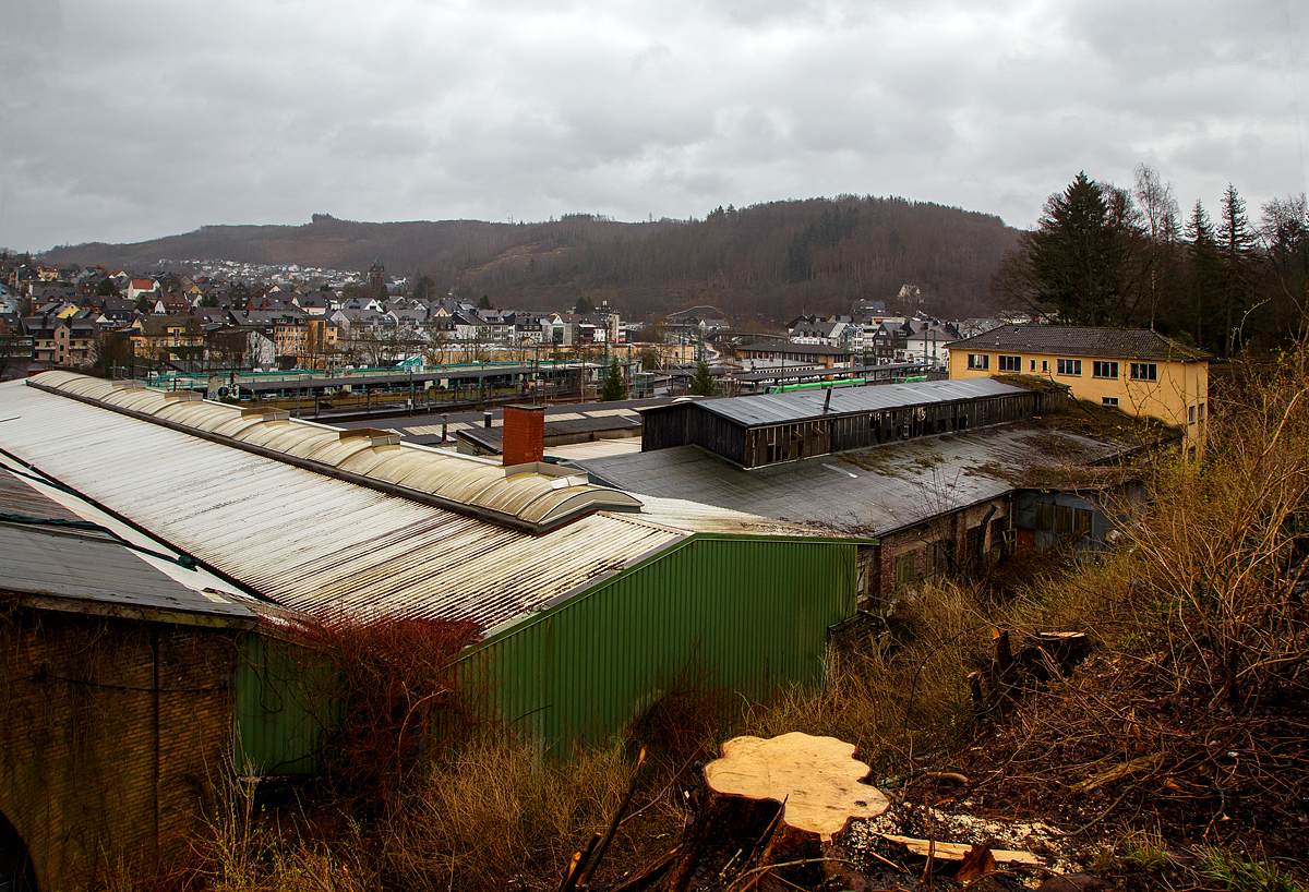 Diesen Blick (hier am 20.02.2022) auf das ehemalige AW Betzdorf (Sieg), zu Reichsbahnzeiten auch Eisenbahnausbesserungswerk (EAW), wird es wohl nicht mehr lange geben. Wobei dieser Blick erst seit kurzem möglich ist, da nun hier die Bäume abgeholzt sind.

In den letzten Jahren waren die Hallen noch an einen großen Büromöbel und Lagerkästen Hersteller der Region vermietet. Bald soll es noch Plänen der Stadt, zu Betzdorfs neuen Mittelpunkt der Stadt werden. Auf dem ca. 10.000 m² großen Areal sollen Wohnungen, Einkaufmöglichkeiten und Arbeitsplätze entstehen. So steht wohl bald diesen Gebäuden auch der Abriss bevor. Hier am 18.01.2022 waren son die ersten Vermessungen im Gange. Der ehemalige Ringlokschuppen wurde bereits 2013/14 abgebroch.

Hinten der Bahnhof Betzdorf (Sieg).