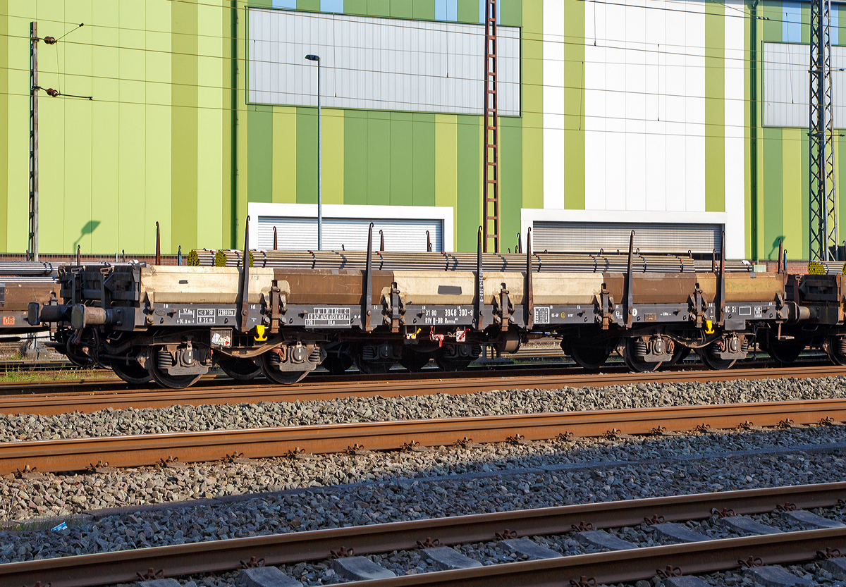 Drehgestellflachwagen mit vier Rads�tzen, mit Seiten- und Stirnwandklappen und mit Rungen RIV 31 80 3948 300-9 D-DB, Gattung Remms 665, der DB Cargo AG, am 08.04.2017 mit Rundstahl aus Edelstahl beladen, abgestellt in Siegen-Geisweid.

Die Wagen haben abklappbare Aluminium-Seitenborde, die durch 10 Fallrungen gesichert werden. Auf Feststellbremsen und die selbstt�tige Lastabbremsung wurde bei den Remms 665 verzichtet.

Der Wagen dient mit aufgeklappten Ladeschwellen zur Bef�rderung von schweren Walzprofilen und anderen sperrigen und schweren G�tern.
Mit eingeklappten Ladeschwellen, also mit ebener Ladefl�che, eignet er sich auch f�r die Bef�rderung von schweren Kettenfahrzeugen.

Vor den umklappbaren Stirnwandklappen sind je zwei absenkbare Rungen angeordnet. Der Wagen kann mit umgelegten Stirnwandklappen und abgesenkten Rungen gefahren werden. An jeder L�ngsseite des Wagens sind 6 Drehrungen und im Fu�boden insgesamt 12 absenkbare Verzurreinrichtungen angeordnet. Mit heruntergeklappten Seitenwandklappen kann der Wagen nur mit Ladema��berschreitung bef�rdert werden. Der Fu�boden besteht aus Kiefernbohlen mit den Abmessungen 70 x 180 mm. Er kann eine Radlast von 5,0 t aufnehmen. Im Fu�boden sind 6 geteilte, klappbare Ladeschwellen eingebaut.

TECHNISCHE DATEN:
Spurweite: 1.435 mm (Normalspur)
Gattung/Bauart: Remms 665 
Erstes Baujahr:	1976
Anzahl der Achsen: 4 in 2 Drehgestellen
L�nge �ber Puffer: 14.040 mm
Drehzapfenabstand: 9.000 mm
Achsabstand in den Drehgestellen: 1.800 mm
Eigengewicht: 21.800 kg
Ladel�nge: 12.644 mm
Ladebreite: 2.780 mm
Ladefl�che: 36,0 m�
Bordwandh�he: 	520 mm
Rungenh�he: 1.275 mm
Maximale Ladegewicht: 58,0 t
H�chstgeschwindigkeit: 100 km/h (beladen) / 120 km/h (leer)
Kleinster befahrbarer Gleisbogenhalbmesser: 35 m
Feststellbremse 	ohne Feststellbremse
Bauart der Bremse 	KE-GP
Art der Lastabbremsung: zweistufig, mechanisch, von Hand umzustellen
