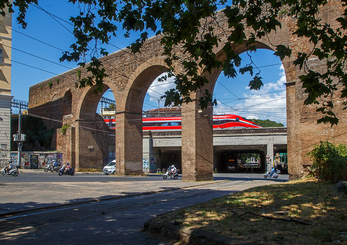 Durch das Aquädukt („römische Wasserleitung“) bei der Porta Maggiore (italienisch größeres Tor) in Rom geschaut....
Oben erreicht am 13.07.2022 ein Trenitalia Frecciarossa 1000 (ETR 400) den Bahnhof Roma Termini, während unten der achtachsige fünfgliedrige Cityway I Gelenktriebwagen ATAC 9101 (Azienda per i Trasporti Autoferrotranviari del Comune di Roma) als Linie 3 bald die Zielstation Porta Maggiore erreicht.
