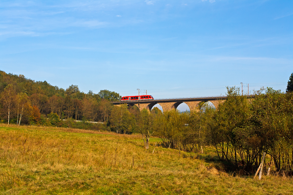 
Ein Alstom Coradia LINT 41 (Dieseltriebwagen BR 648) der DreiL�nderBahn f�hrt am 02.10.2014 als RB 95 (Dillenburg-Siegen-Au/Sieg) �ber den Rudersdorfer Viadukt in Richtung Siegen, n�chster Halt ist Siegen Hbf. 

Der Rudersdorfer Viadukt ist eines der drei Ingenieur-Gro�bauwerke im n�rdlichen Abschnitt der Dillstrecke (KBS 445)  zwischen Siegen und Haiger auf dem Gebiet des heutigen Ortsteils Rudersdorf der Gemeinde Wilnsdorf, im Bereich von Streckenkilometer 114,9. 

Aufgrund der schwierigen Topografie und der begrenzten technischen M�glichkeiten war eine direkte Verbindung zwischen Siegen, Haiger und dar�ber hinaus Dillenburg zum Zeitpunkt des Baus der Deutz-Gie�ener Bahn vom heutigen K�ln-Deutz nach Gie�en beim Bau dieser Strecke in den 1850er-Jahren noch nicht m�glich. 

Erst 1915 wurde diese direkte Verbindung zwischen Siegen und Haiger fertiggestellt. Das war vor allem f�r den aus dem Ruhrgebiet nach S�den f�hrenden Kohleverkehr wichtig. M�glich wurde diese Streckenf�hrung durch die drei gro�en Ingenieurbauwerke: Den Niederdielfener Viadukt, den Rudersdorfer Viadukt und den Rudersdorfer Tunnel.