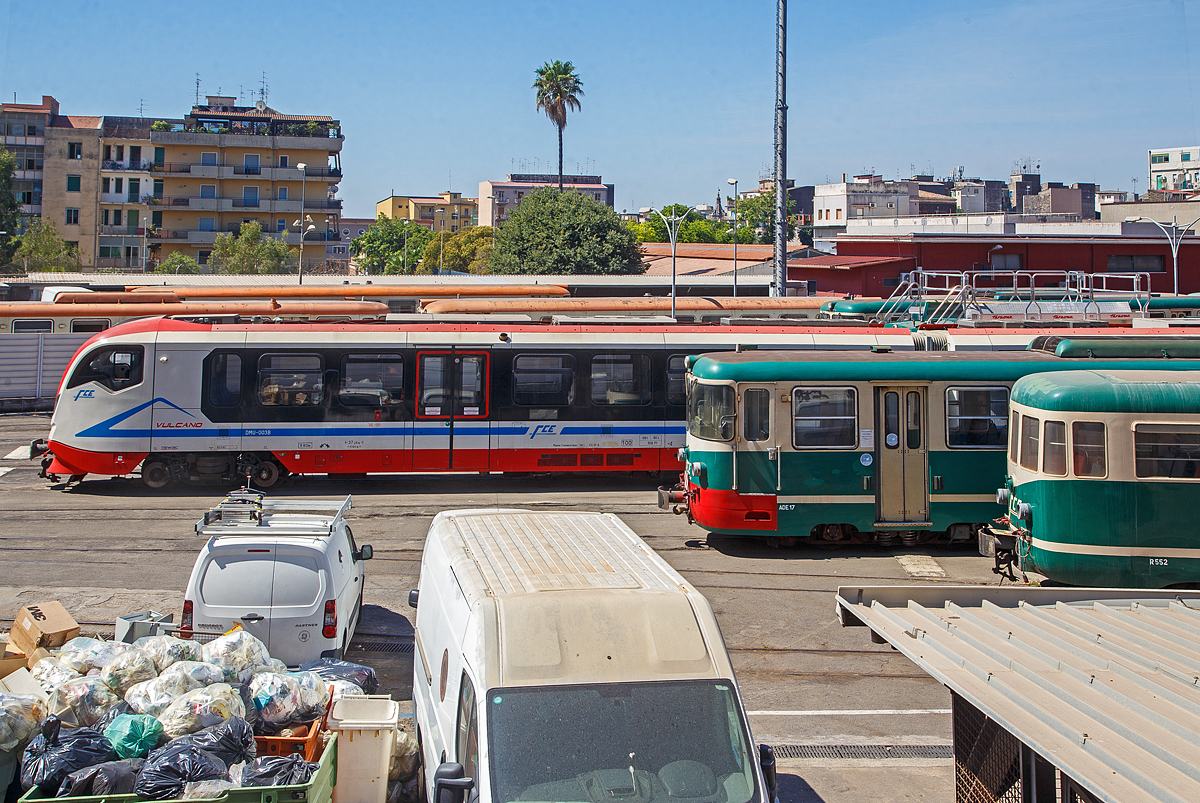 Ein Blick ins Depot der Ferrovia Circumetnea (FCE) in Catania Borgo am Sonntag den 17.07.2022, leider ruht sonntags der ganze Bahnbetrieb der 950 mm Schmalspurbahn.

Links der moderne Dieseltriebzug FCE DMU-003 vom Typ Newag „Vulcano“ (series DMU 001-004). Davor der Triebwagen FCE ADe 17 (Baujahr 1980), sowie davor der Beiwagen FCE R552.

Der Newag „Vulcano“ (Baureihe DMU 001-004) ist ein Dieseltriebwagen, der vom polnischen Hersteller NEWAG S.A. f�r die Ferrovia Circumetnea in Catania gebaut wurde. Seit Mai 2016 sind sie im Einsatz. 

Die Vulcano sind moderne, zweiteilige Fahrzeuge, die mit integrierten „Powerpack“-Antriebssystemen mit elektrischem Getriebe ausgestattet sind, die speziell f�r diese Fahrzeuge entwickelt wurden. Fortschrittliche technische L�sungen im Antriebssystem, Getriebesystem und Karosseriest�tzsystem erm�glichten es, Ger�usche im Fahrgastraum zu d�mpfen. Die Konfiguration des Innenraums des Fahrgastraums erm�glicht den Betrieb des Fahrzeugs sowohl im Stadt- als auch im Vorortverkehr. Die Anzahl der Sitzpl�tze betr�gt 106 inkl. 7 Klappsitze und kann je nach Bedarf des Schienenverkehrstr�gers variiert werden. Die Fahrzeuge sind vollklimatisiert.

Eine Einheit ist mit einer behindertengerechten Toilette (gem�� TSI PRM) in hermetisch dichter Bauweise ausgestattet und die interne T�rzone ist mit automatischen Rollstuhlliften ausgestattet. Diese Dieseltriebz�ge k�nnen mit einer H�chstgeschwindigkeit von bis zu 100 km/h fahren und sind f�r Mehrfachtraktion ausgelegt.

TECHNISCHE DATEN der Newag „Vulcano“:
Hersteller: Newag S.A.
Gebaute: 4
In Betrieb: Mai 2016
Spurweite: 950 mm
Achsfolge: Bo'Bo'+Bo'Bo'
L�nge: 37.260 mm
H�he: 3.530 mm
Breite: 2.526 mm
Drehzapfenabstand: 11.600 mm
Eigengewicht: 68,8 t
Leistung: 2 x 390 kW
H�chstgeschwindigkeit: 100 km/h
T�ren ja Seite: 2 (je 1.300 mm breit)
Fu�bodenh�he �ber SOK: 550 mm
Sitzpl�tze: 106
Stehpl�tze: 66

