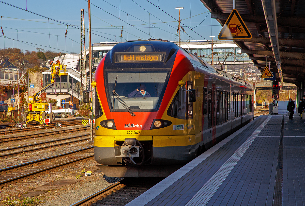 Ein FLIRT im Licht und Schatten....
Der 3-teilige Stadler FLIRT 427 042 / 827 042 / 427 542 (94 80 0427 124-3 D-HEB / 94 80 0827 124-9 D-HEB / 94 80 0427 624-2 D-HEB) der HLB Bahn (Hessischen Landesbahn) hat am 12.11.2021, als RE 99 Gießen – Siegen (Umlauf HLB 24936), den Hauptbahnhof Siegen erreicht.

Der Triebzug wurde 2010 von Stadler Pankow in Berlin unter den Fabriknummern 38623/38624, 38623/38626 und 38623/38625 gebaut und an die HLB geliefert.

Die Bezeichnung „FLIRT“ steht für „Flinker Leichter Innovativer Regional Triebzug“. Seit Dezember 2010 sind für die HLB die dreiteiligen (Baureihe 427) und fünfteiligen (Baureihe 429) elektrischen Niederflurtriebzüge des Typs FLIRT der Firma Stadler Pankow GmbH im „Main-Lahn-Sieg-Netz“ im Einsatz. Die Triebzüge entsprechen höchsten Komfortansprüchen und sind in Aluminium-Leichtbauweise gebaut.

Technische Daten:
Spurweite: 1.435 mm (Normalspur)
Achsformel: Bo'2'2' Bo'
Länge über Scharfenberg-Kupplung: 58.178 mm
Breite:  2.880 mm
Höhe: 4.185 mm
Achsabstände im Drehgestell: 2.700 mm
Triebraddurchmesser: 870/800 mm (neu/abgenutzt)
Laufraddurchmesser: 750/690 mm (neu/abgenutzt)
Dauerleistung am Rad: 1.500 kW
Max. Leistung am Rad: 1.950 kW
Anfahrzugkraft baulich (bis 55 km/h): 150 kN
Max. Beschleunigung bis 80 km/h: 1,01 m/s²
Höchstgeschwindigkeit: 160 km/h
Leergewicht: 100 t
Speisespannung: 15 kV, 16 1/3 Hz
Sitzplätze: 16 (1. Kl.) / 116 (2. Kl.) / 48 Klappsitze