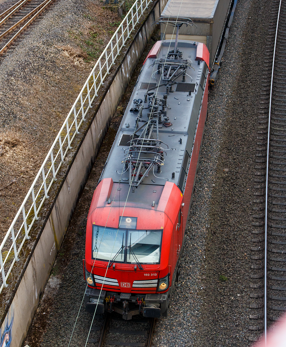 Ein Luftbild der 193 313 von der Brücke in Betzdorf-Bruche.... 
Die 193 313 (91 80 6193 313-4 D-DB), eine Siemens Vectron MS, der DB Cargo AG fährt mit einem KLV-Zug in Richtung Köln. 

Die DB Cargo 193 313 eine Vectron MS wurde 2018 von Siemens in München-Allach unter der Fabriknummer 22414 gebaut und an die DB Cargo geliefert. Diese Vectron Lokomotive ist als MS – Lokomotive (Multisystem-Variante) mit 6.400 kW konzipiert und zugelassen für Deutschland, Österreich, Schweiz, Italien und Niederlande (D/A/CH/I/NL), sie hat eine Höchstgeschwindigkeit von 200 km/h. So ist es möglich ohne Lokwechsel vom Mittelmeer die Nordseehäfen Rotterdam oder Hamburg an zu fahren.