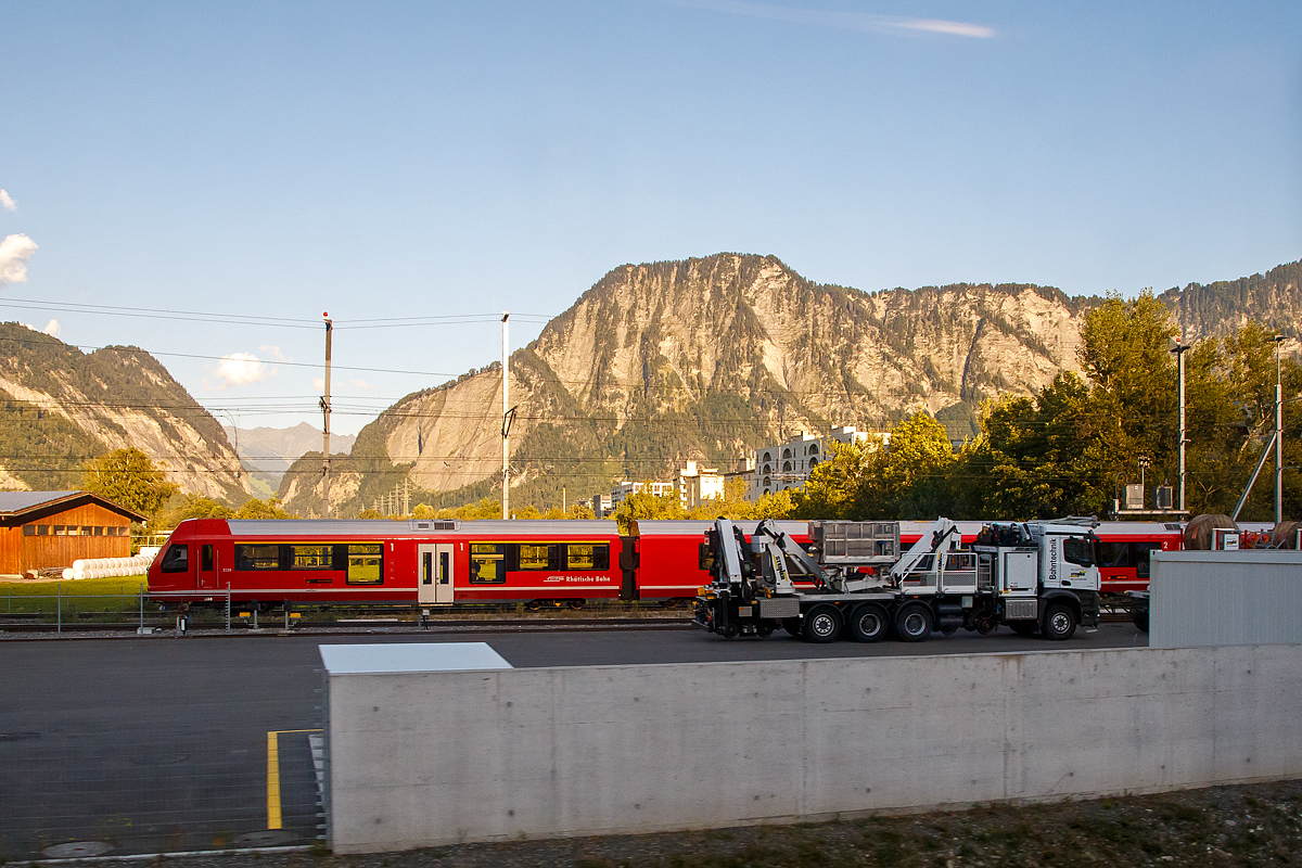 Ein Mercedes Zweiwege-Lkw der Steiner Bahntechnik (Rikon-CH) als Oberleitungsmontagefahrzeuge mit zwei Gelenkbühnen, Kran sowie je einem Fahrdraht- und Tragseildrücker am 05.09.2021 beim Bahnhof Landquart. Davor (nicht im Bild) ein Zweiwege-Anhänger, dahinter fährt gerade der RhB ABe 4/16 Capricorn-Triebzug 3126 ein. Aufgenommen aus dem Zug heraus.
So wie ich es sehr ist der Zweiwege-Lkw für die Spurweite 1.000 mm (Meterspur) ausgeführt.