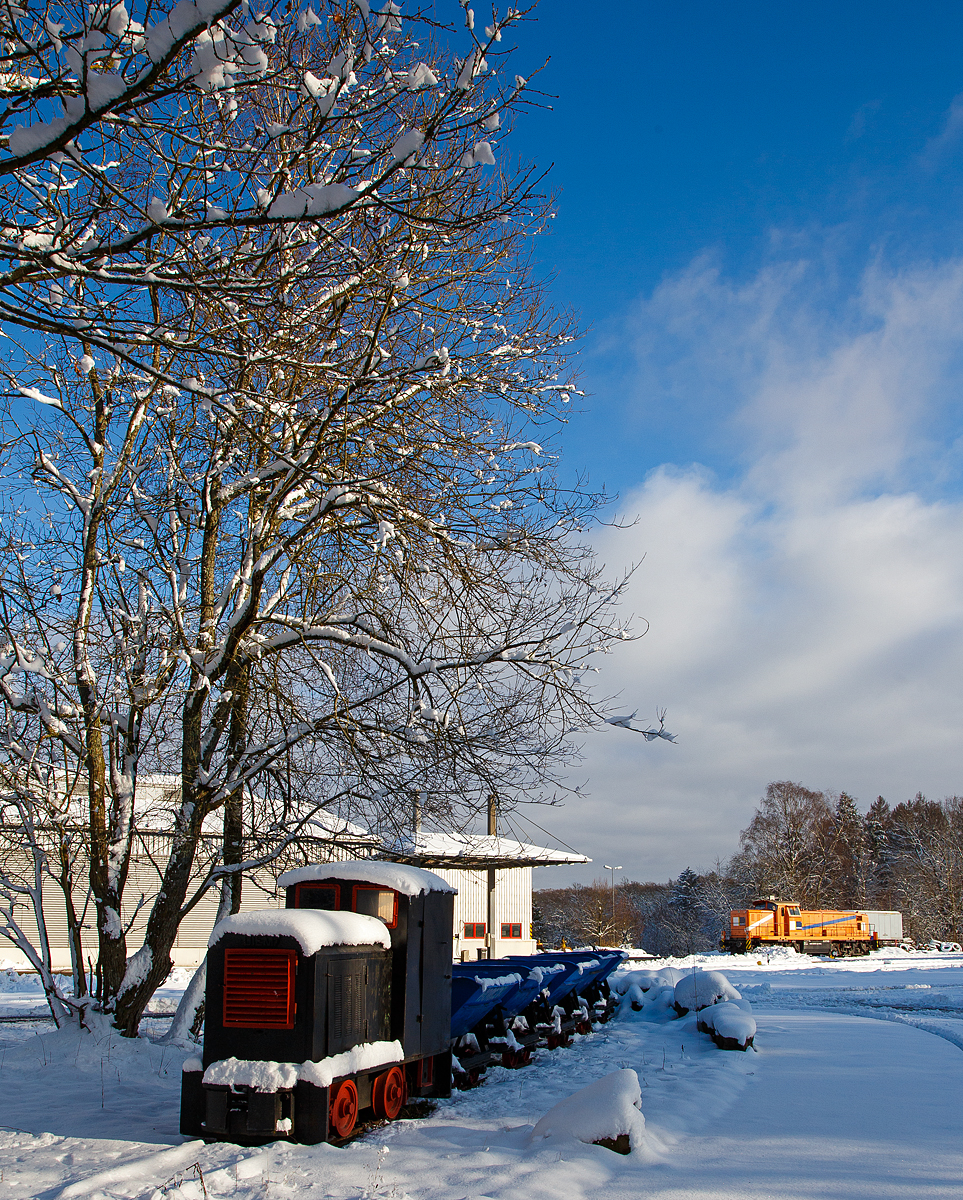 Eine 600mm DIEMA Feldbahnlok mit einem Lorrenzug als Denkmal am 09.01.2021 bei dem Betriebshof der Westerwaldbahn (WEBA) auf der Bindweide bei Steinebach/Sieg. Der Typ und Baujahr sind mir unbekannt. 

Im Hintergrund die an die HERING Bahnbau (Burbach) vermietete 291 972-8 (98 80 3291 972-8 D-NRAIL) eine Sonderbauart MaK G 1600 BB der Northrail (Hamburg).