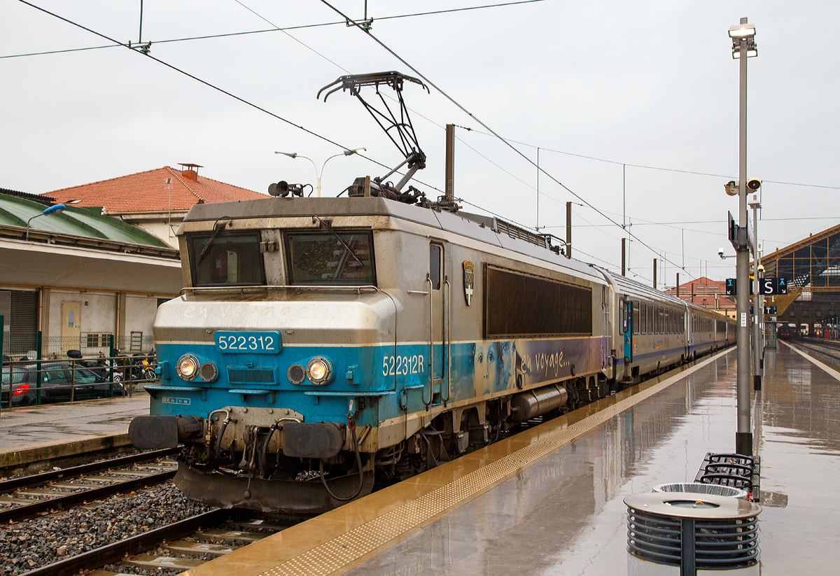 
Für Jeanny, eine nez cassé en livrée  En Voyage....  
Die SNCF BB 22312  Antibes / Juan-les-Pins  (BB 522312R bzw. UIC: F-SNCF 91 87 0022 312-) steht am 25.03.2015 mit einem TER Regionalzug im Bahnhof Marseille Saint-Charles bereit. 

An Hand der ersten Ziffer vor der Loknummer (5), kann man die die Zugehörigkeit zum Geschäftsbereich der SNCF erkennen, die  5  steht für TER (Regionalverkehr). 
Mit der Aufgliederung der SNCF in verschiedene Geschäftsbereiche wurde der Bestand zum 1. Januar 1999 aufgeteilt, die Zugehörigkeit kann man an der ersten Ziffer erkennen:
1 = VFE (Fernverkehr),
2 = CIC (überregionaler Personenverkehr),
4 = Fret (Güterverkehr)
5 = TER (Regionalverkehr)
6 = Infra (Betrieb und Unterhaltung)
7 = Dirction du Material (Materialwirtschaft)
8 = Transilien (Vorortverkehr im Großraum Paris)

Das  R  hinter der Loknummer zeigt dass diese Lok Wendezugtauglich ist. Ab 2006 wurden einige BB 22200 mit Wendezugsteuerungen versehen, zur Kennzeichnung, wurde wie bei dieser, der Loknummer das  R  (R = réversible) nachgesetzt. 

Die Lok  BB 22312 trägt das Wappen der französischen Stadt Antibes / Juan-les-Pins, diese liegt an der Eisenbahnstrecke von Marseille nach Monaco (zwischen Cannes und Nizza) an der Côte d’Azu. Juan-les-Pins ist ein Seebad an der Côte d’Azur. Der Ort gehört zur Gemeinde Antibes und liegt im Département Alpes-Maritimes in der Région Provence-Alpes-Côte d’Azur.