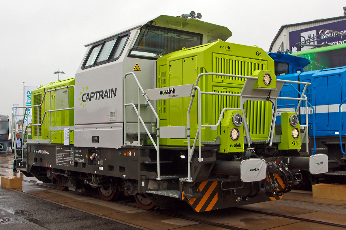 
Für Vossloh die 100sten G6, für hellertal.startbilder.de die erste....

Eine sehr erfolgreiche 3-achsigen dieselhydraulische Rangierlokomotive ist die Vossloh G 6 für den schweren Rangierdienst. Der Kieler Lokhersteller Vossloh Locomotives GmbH hat bereits die 100sten G6 verkauft, so wurde die 98 80 0650 100-7 D-VL eine Vossloh G 6 der Captrain Deutschland GmbH das auf der Inno Trans 2014 in Berlin (hier 26.09.2014) präsentiert und auch an Captrain übergeben.

Diese Lok wurde 2013 unter der Fabriknummer 5101982 gebaut. Die Loks vom Typ Vossloh G6 zeichnen sich, für eine 3-achsigen Rangierlokomotive, als Kraftpaket aus (hohe Leistung und Anfahrzugkaft).

Technische Daten:
Spurweite: 1.435 mm
Achsfolge:  C
Länge über Puffer: 10.790 (bei dieser Vers.)
Achsabstand: 4.400 mm (1.700 mm / 2.700 mm)
Größte Breite:  3.080 mm
Größte Höhe über Schienenoberkante: 	4.225 mm
Raddurchmesser neu:	1.000 mm
kleinster befahrbarer Gleisbogen:	50 m
Dieselmotor:  Cummins, MTU oder Caterpillar
Dieselmotorleistung: 690 kW
Getriebe: Voith L 3r4 zseU2
Gewicht: 60 t
Anfahrzugkraft: ca.200 kN
Höchstgeschwindigkeit:  80 km/h (geschleppt 100 km/h)
Kleinste Dauergeschwindikeit:  3 km/h (im Rangiergang)
Kleinster bef. Gleisbogen: 	50 m
