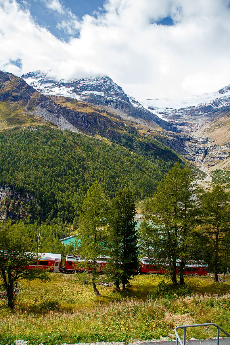 Geführt von den beiden RhB Triebwagen ABe 4/4 III - 51  Poschiavo  und ABe 4/4 III - 53  Tirano  fährt der Regionalzug nach Tirano am 13.09.2017 von Alp Grüm hinab ins Puschlav.

Unten der Lago Palü (Lagh da Palü, dt. Palüsee) am Fuße des Piz Palü. Der See wird größtenteils vom Palügletscher gespeist, den man (heute nur noch) oben rechts im Bilderahnen kann.