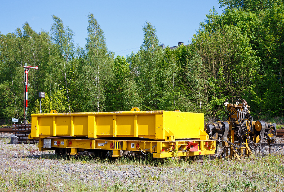 Gleisbauanh�nger T5020-2 (Schienengebundenes Ger�t Registrier Nr. 9983 021) mit Schottermulden der DB Bahnbaugruppe GmbH, abgestellt am 18.05.2015 beim Bahnhof Herdorf.

Der Wagen kann mit Schottermulden oder anderen Aufbauten durch ISO-Twistlocks genutzt werden. F�r den Material- und Werkzeugtransport sind diverse Zurrpunkte sowie Rungeneins�tze vorhanden.

Technische Daten:
Hersteller: GOS Tool & Engineering Services Ltd, Blaenavon (Wales - GB)
Baujahr: 2014
Fabriknummer: T00016
Achsanzahl: 2
Raddurchmesser: 500 mm
Spurweite: 1.435 mm
L�nge �ber Kupplung: 5.300 mm
Breite: 2.420 mm
Achsstand: 4.600 mm
H�he: 575 mm �ber SOK
Eigengewicht: 3.100 kg (ohne Mulde)
Nutzlast: 19,9 t
H�chstgeschwindigkeit (Hg): 20 km/h (in Kreuzungen und Weichen 10 km/h) 
Bremse: Automatische Federspeicherbremse 
Anmerkung: Der Wagen darf nur im gesperrten Gleis o. im Baugleis verwendet werden.