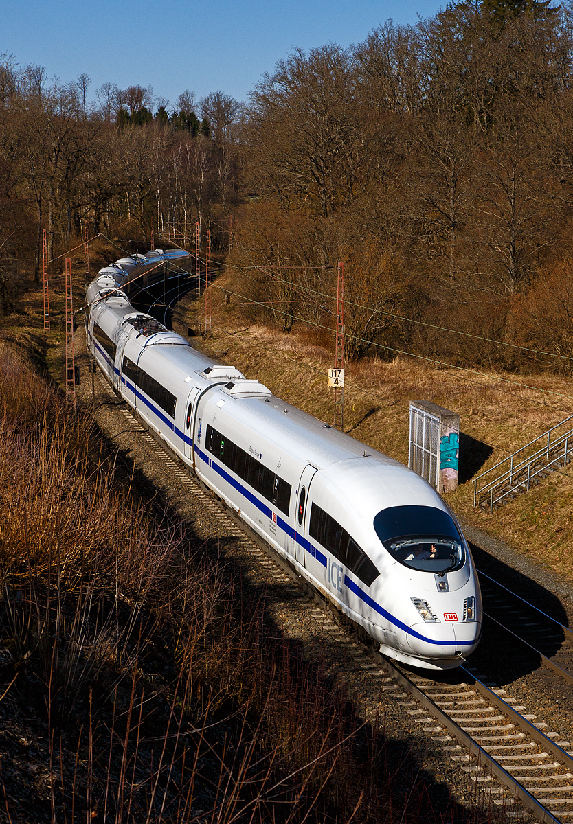 Highlight des Tages.... Wenn der Prophet nicht zum Berg kommt, dann muss der Berg halt zum Propheten...
Der ICE 3 M – Triebzug 4601 – DB 406 501-7 / 406 001-8 „Europa/Europe“ mit Blauen Streifen der DB Fernverkehr AG fährt am 07.03.2022 bei Wilnsdorf-Ruderdorf (Kr. Siegen) über die Dillstecke in Richtung Frankfurt. Gleich geht es in den 2.652 m langen Rudersdorfer Tunnel.

Einen lieben Gruß an den freundlich grüßenden Lokführer zurück. Sorry, ich hatte den Gruß durch den Sucher nicht gesehen.

Der Triebzug wurde 2001 gebaut, er besteht auch acht Wagen, im Einzelnen aus dem:
Endwagen 8   UIC-Nr. 406 501-7
Trafowagen 7   UIC-Nr. 406 601-5
Stromrichterwagen 6  UIC-Nr. 406 701-3
Mittelwagen 5   UIC-Nr. 406 801-1
Mittelwagen 4   UIC-Nr.  406 301-2
Stromrichterwagen 3  UIC-Nr 406 201-4
Trafowagen 2   UIC-Nr. 406 101-6
Endwagen 1   UIC-Nr.  406 001-8

Der Triebzug hat die Zulassungen für Deutschland, Belgien (ETCS) und die  Niederlande. Der ICE 3M ist eine Triebwagenzug und nicht wie ICE 1 und 2 mit Triebkopfkonzept. Gegenüber den äußerlich gleichen ICE 3 (BR 403) sind sie mehrsystemfähig (15 kV 16,7 Hz~ / 25 kV 50 Hz~ / 1,5 kV = / 3 kV =). In Deutschland fahren sie planmäßig bis zu 300 km/h (technisch möglich und zugelassen 330 km/h). Unter Gleichstrom (wie in Belgien 220 km/h).