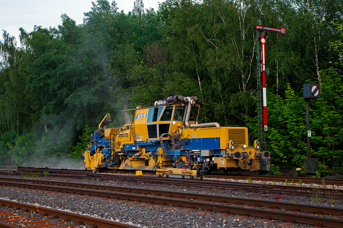 Im Einsatz am Gleis 4 im Bahnhof Herdorf am Abend des 11.06.2021: Die Plasser & Theurer Schotterverteil- und Planiermaschine SSP 110 SW, Schweres Nebenfahrzeug Nr. D-DGU 99 80 9425 068-0, der DGU - Deutsche Gleisbau Union aus Koblenz, ex 97 16 46 516 18-9 D-DGU (ex Hering Gleisbau, ex Volker-Rail). 