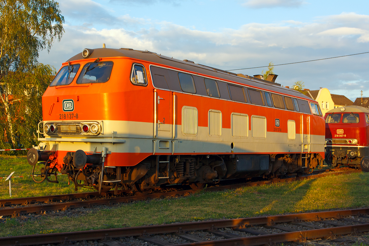 Im letzten Sonnenlicht....
Die ehemalige City-Bahn Lok 218 137-8 in orange/kieselgrau am 14.06.2014 im DB Museum Koblenz.

Die V 164 wurde 1971 bei Henschel in Kassel unter der Fabriknummer 31539 gebaut und als 218 137-8 an die DB (in altrot) geliefert. F�r das Projekt CityBahn auf der Strecke K�ln – Gummersbach (Aggertalbahn) wurden 1984 zehn Lokomotiven des Betriebswerks Hagen passend zum Wagenzug in reinorange (RAL 2004) mit kieselgrauer Bauchbinde umlackiert, so auch dies Lok.

Technische Daten:
Achsformel:  B'B'
Spurweite:  1.435 mm
L�nge: 16.400 mm
Gewicht:  80 Tonnen
Radsatzfahrmasse:  20,0 Tonnen
H�chstgeschwindigkeit:  140 km/h
Motor: Wassergek�hlter V 12 Zylinder Viertakt MTU - Dieselmotor vom Typ 12 V 956 TB 11 (abgasoptimiert ) mit Direkteinspritzung und Abgasturboaufladung mit Ladeluftk�hlung
Motorleistung: 2.800 PS (2.060 kW) bei 1500 U/min
Getriebe: MTU-Getriebe K 252 SUBB (mit 2 hydraulische Drehmomentwandler)
Leistungs�bertragung: hydraulisch
Tankinhalt:  3.150 l
