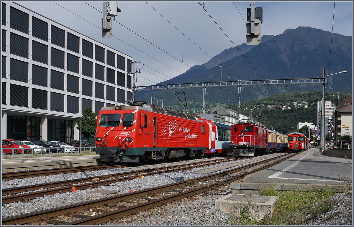 Im MGB Bahnhof von Brig zeigt sich neben der MGB HGe 4/4 II  Monte Rosa  die FO HGe 4/4 36 (Baujahr 1948) mit dem  Glacier Pullman Express . 

31. August 2019