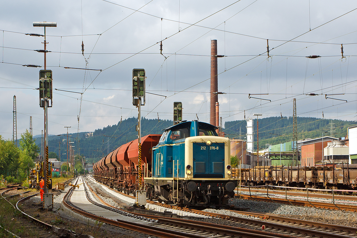 
In Siegen-Geisweid (ehemals Hüttental-Geisweid) werden die Ausweich- und Abstellgleise erneuert.... 
Die 212 376-8 der Aggerbahn (Andreas Voll e.K., Wiehl), ex DB V 100 2376, ex DB 212 376-8, rangiert am 14.07.2014 einen Schotterzug in die Baustelle.  Rechts im Hintergrund das Stahlwerk Geisweid der Deutsche Edelstahlwerke GmbH (ehemals Stahlwerke Südwestfalen).
Übrigens ist das Personal von den Aggerbahn sehr freundlich und nett.

Die Lok, vom Typ V100.20 wurde 1965 bei Deutz unter der Fabrik-Nr. 57776 gebaut und als V 100 2376 an die Deutsche Bundesbahn ausgeliefert, 1968 erfolgte die Umzeichnung in 212 376-8. Die Ausmusterung bei der DB erfolgte 2010, über ALS - ALSTOM Lokomotiven Service GmbH in Stendal kam sie 2011 zur Aggerbahn.
