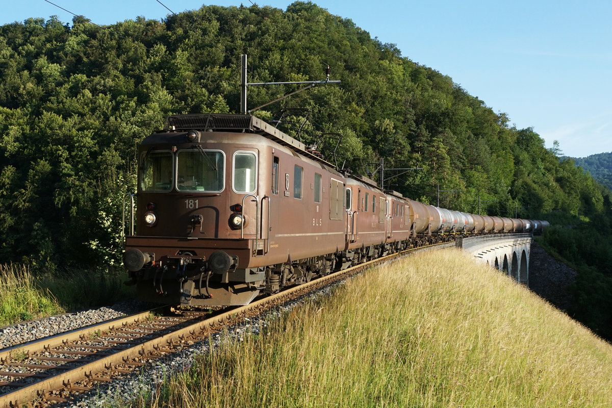 JAHRESRÜCKBLICK 2018
von Walter Ruetsch
Serie Nr. 2
Von Ende Juni bis Mitte August 2018 wurden zahlreiche IC- und Güterzüge Olten-Basel wegen Bauarbeiten an der Hauptstrecke über die alte Hauensteinlinie umgeleitet. Kesselwagenzug mit drei BLS Re 425 im letzten Abendlicht bei Rümlingen am 12. Juli 2018.
