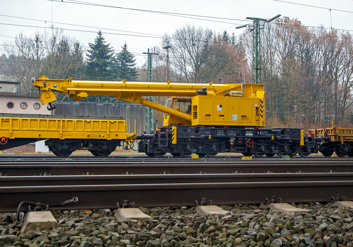 
KIROW 50t-Gleisbauschienenkran MULTI TASKER KRC 400 T der Hering Bau (Burbach), Schweres Nebenfahrzeug Nr. 97 82 4950 119-5 D-HGUI, abgestellt am 24.11.2018 in Kreuztal. 

Vor und hinter dem Kran jeweils ein Schutzwagen, vorne der 80 80 3900 002-7 D-HGUI Schutzwagen der Gattung Rs und hinten der 80 80 3948 003-9 D-HGUI Schutzwagen der Gattung Res.

Der Kran KIROW KRC 400 T wurde 1996 von Kirow in Leipzig unter der Fabriknummer 106700 gebaut und an die Hering Bau geliefert. Die Firma Hering Bau geh�rt in Deutschland zu den gr��ten Eisenbahnkran-Dienstleistern, sie hat 10 eigene Krane.

Der 50-t-Eisenbahndrehkran wird f�r den Aus-und Einbau von schweren Betonweichen, Gleisjochen und Hilfsbr�cken sowie f�r die Montage von Ingenieurbauwerken eingesetzt. Bei Havarien auf Bahnstrecken leistet er schnelle Hilfe zum Bergen schwerer Lasten.

TECHNISCHE DATEN:
Spurweite: 1.435 mm 
Achsanzahl: 8
Achsfolge: unbek.
L�nger �ber Puffer: 11.000 mm (ohne Kranausleger)
Drehzapfenabstand: 6.000 mm
Achsabstand im Drehgestell: 2 x 1.500 mm = 3.000 mm
Lauf.- und Treibraddurchmesser: 920 mm (neu)
Eigengewicht: 111 t
Fahrgeschwindigkeit im Zugverband (geschleppt): 120 km/h
Fahrgeschwindigkeit mit Eigenantrieb: 20 km/h
Zugelassen f�r Streckenklasse: CS 04 (Schwerwagengruppe)
kleinster befahrbarer Radius: 90 m
Bremse: KE-GPmZ
Handbremse: ja

