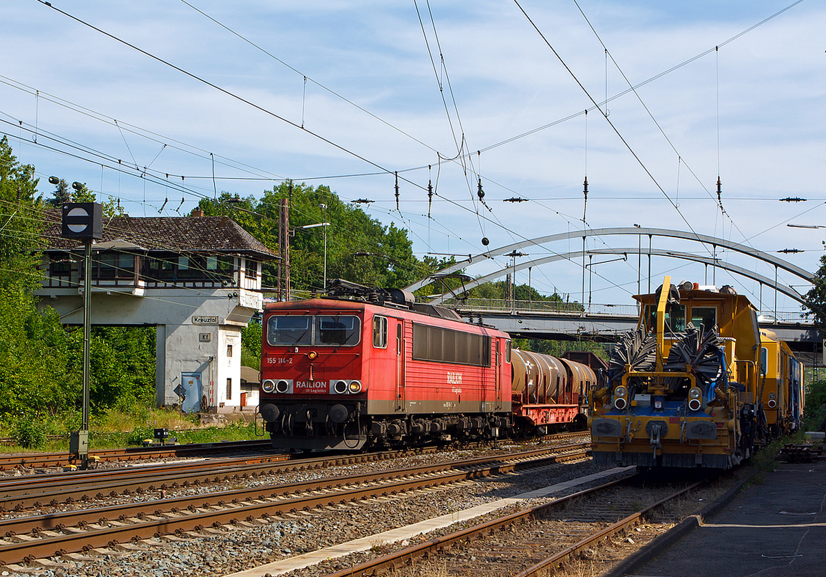 Links die abgestellten Schnellschotterplaniermaschine SSP 110 SW und die Plasser und Theurer Universalstopfmaschine Unimat 09-475/4S versperren etwas die Sicht.....
Die 155 114-2 der DB Schenker Rail Deutschland AG, ex DR 250 114-6, ist am 18.07.2014 in Kreuztal mit einem schweren gemischten Güterzug in Richtung Hagen losgefahren.

Der Güterzug wurde von der 140 600-8 nachgeschoben (bis Welschen Ennest). Ein Bild davon gibt es unter: http://hellertal.startbilder.de/bild/deutschland~strecken~kbs-440-ruhr-sieg-strecke/354229/die-140-600-8-der-db-schenker.html

Der Stromcontainer wurde 1980 bei LEW (VEB Lokomotivbau Elektrotechnische Werke Hans Beimler) in Hennigsdorf unter der Fabriknummer 16705 gebaut und als 250 114-6 an die DR (Deutsche Reichsbahn) geliefert, 1992 umgezeichnet in DR 155 114-2 und 1994 in DB 155 114-2

Seit 2007 hat sie die NVR-Nummer  1 80 6155 114-2 D-DB.

(BB-Bild ohne OL-Mast im rechten Bildrand)