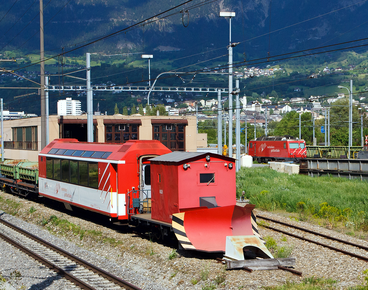 
MGB Schneeplug X2906, ein zweiachsiger Spurpflug, abgestellt am 28.05.2012 beim Werkstattareal in Brig, aufgenommen aus einem fahrenden IR.