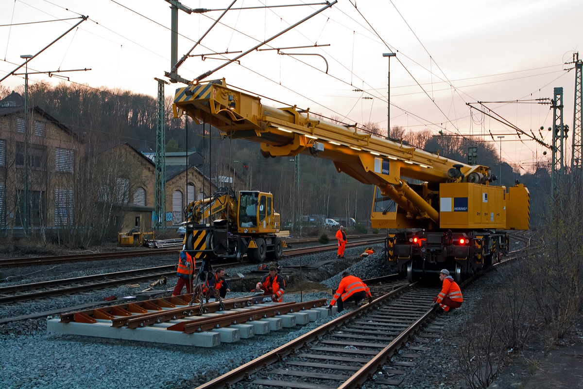 .
Mit Hilfe von dem 125t - KIROW Gleisbauschienenkran KRC 810 T  BALU  der Hering Bau (Burbach), Schweres Nebenfahrzeug Nr. 97 82 53 508 19-3, wird am 27.03.2014 das erste St�ck der neuen Kreuzungsweiche (Nr. 82) im Bahnhof Betzdorf/Sieg gesetzt. Der komplette Abzweig der KBS 460 (Siegstrecke) an die KBS 462 (Hellertalbahn) und KBS 463 (Daadetalbahn) bzw. Gleis 102 und Gleis 101 wird erneuert.

Technische Daten von dem 125-t-Eisenbahndrehkran:
Eigengewicht: 128 t
L�nge �ber Puffer: 13.000 mm
Achsanzahl: 8
Drehzapfenabstand: 8.000 mm
Drehzapfenabstand im Drehgestell 1 und 2: 2.300 mm
Achsabstand in den Einzeldrehgestellen: 1.100mm
Ergebene Achsabst�nde in m: 1,1 / 1,2 / 1,1/ 4,6 / 1,1 / 1,2 / 1,1
Achsfolge: 1'A'1A'A1'A1'
Achslast: 16,0 t
Motorleistung: 235 kW
Fahrgeschwindigkeit im Zugverband: 120 km/h
Fahrgeschwindigkeit mit Eigenantrieb: 20 km/h
zul. Anh�ngelast: 80 t
Zugelassen als Schwerwagen f�r Streckenklasse: CS 05
kleinster befahrbarer Radius: 90 m

Tragf�higkeiten:
bei 0,00 m Ausladung vor Puffer, mit Schwerlastausr�stung: 125 t
bei 2,80 m Ausladung vor Puffer, � 30�, abgest�tzt: 90 t
bei 2,80 m Ausladung vor Puffer, � 20�, freistehend: 46 t 