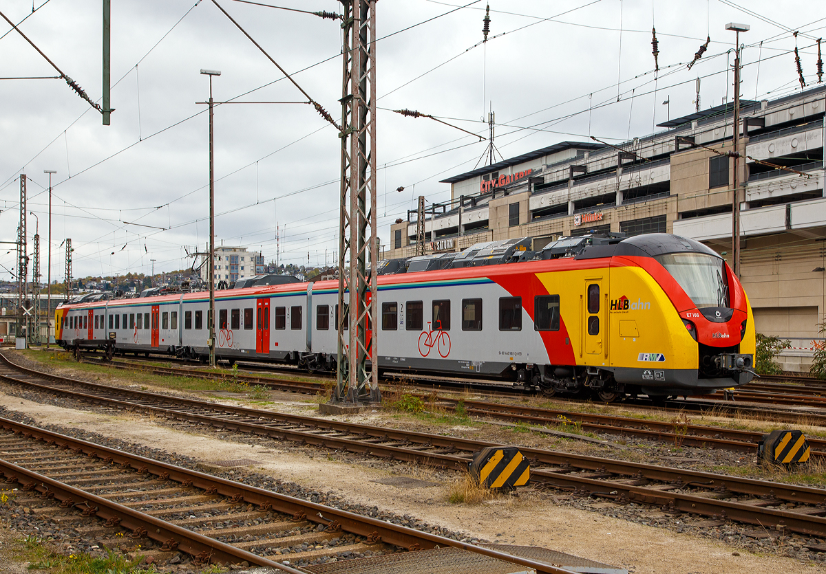 
Momentan sind auch 2 vierteilige HLB  Grinsekatzen  zu Besuch in Siegen....
Der ET 166 (94 80 1440 166-5 D-HEB / 94 80 1441 666-3 D-HEB / 94 80 1441 166-4 D-HEB /  94 80 1440 666-4 D-HEB) ein vierteiliger Niederflur-Elektrotriebwagen vom Typ Alstom Coradia Continental der HLB (Hessische Landesbahn) steht am 28.10.2018 beim Hbf Siegen. Aufgenommen aus dem Südwestfälische Eisenbahnmuseum.

Der vierteilige Niederflur-Elektrotriebwagen wurde 2018 von ALSTOM Transport Deutschland GmbH in Salzgitter unter den Fabriknummern D04 1531 013 A1, D04 1531 011 B, D04 1531 013 C und D04 1531 013 A2 gebaut und an die HLB geliefert. Das Einsatz BW ist Wiesbaden.

Die Triebzüge Alstom Coradia Continental gehören zur Fahrzeugfamilie modularer, niederfluriger elektrischer Nahverkehrs-Gliedertriebzüge Alstom Coradia. Die Züge werden aus einem Baukasten standardisierter Einzelfahrzeuge gebildet, die ihre technische Ausrüstung mit Ausnahme der Fahrmotoren auf dem Dach tragen. Die Endwagen tragen jeweils einen Haupttransformator, einen Antriebsumrichter und einen Nebenbetriebsumrichter. Die Mittelwagen tragen die weiteren Ausrüstungen Stromabnehmer, Kompressor und Batteriekasten. Mittig auf jedem Fahrzeug ist das Klimagerät für den Fahrgastraum angeordnet. 

Die Hessische Landesbahn hat insgesamt 30 dieser neuen Niederflur-Elektrotriebzüge gekauft, 17 vierteilige und 13 dreiteilige ET. Am 27. Juli 2018 erhielten die Züge ihre Zulassung und werden seitdem Probebetrieb eingesetzt. Zudem wurden noch 5 weitere bestellt.

Die Züge erreichen im Einsatz Geschwindigkeiten von bis zu 160 km/h und besitzen ein sehr gutes Beschleunigungsvermögen. Sie können je nach Fahrgastaufkommen auch in Doppeltraktion betrieben werden. Durch ein speziell für Regionalzüge modifiziertes Zugsicherungssystem können die Fahrzeuge auch auf ICE-Strecken fahren. Die Triebzüge sind zudem mit elektrischen Bremsen ausgestattet, die in der Lage sind, beim Bremsvorgang bis zu 30 Prozent der Energie ins Netz zurück zu speisen.



TECHNISCHE DATEN der BR 1440.1:
Hersteller:	Alstom Transport Deutschland GmbH
Spurweite: 1.435 mm
Achsfolge: Bo‘(Bo‘)(2’ )(Bo‘)Bo‘ in Klammern Jakobs-Drehgestelle
Länge über Kupplung: 73.300 mm
Breite: 2.920 mm
Drehzapfenabstände: 15.500 / 16.400 / 16.400 / 15.500 mm
Achsabstand im Enddrehgestell: 2.400 mm
Achsabstand im Drehgestell: 2.700 mm
Maximale Höhe (über SO): 4.280 mm
Eigengewicht: 144 t
Minimaler befahrbarer Gleisbogen Werkstatt/Betrieb: 100/150 m
Niederfluranteil:  ca. 89 %
Sitzplätze: 227 (davon 12 in der 1. Klasse)
Stromsystem: 15 kV / 16,7 Hz
Höchstgeschwindigkeit: 160 km/h
Nennleistung: 2.900 kW
Anzahl Fahrmotoren: 8
Zugbeeinflussungs-System: LZB / PZB 90
