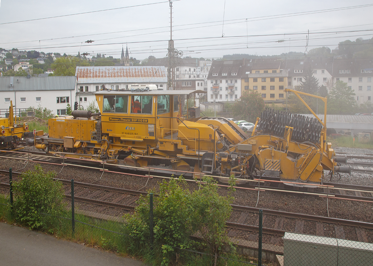 
Nach dem Stopfen folgt meist der Schotterplug....
Die Plasser & Theurer Schotterverteil- und Planiermaschine SSP 110 SW (Schweres Nebenfahrzeug Nr. 97 16 40 575 18-1) der DGU (Deutsche Gleisbau Union) am 16.05.2015 im Einsatz in Siegen zwischen Hauptbahnhof und Siegbrücke.

Die Schotterverteil- und Planiermaschine wurde 2002 von Plasser & Theurer unter der Fabriknummer 717 gebaut und an Reisse Bau GmbH geliefert, zwischenzeitlich war sie Struton Rail GmbH, nun ist sie bei der DGU angelangt.