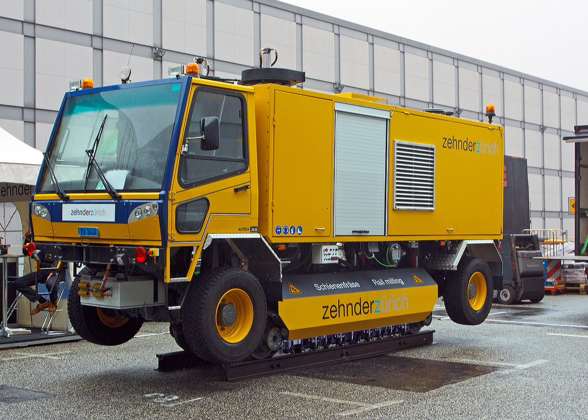 
Neuentwicklung, die 2-Wege-Schienenfräse AT VM 8000-M18 (hier für Meterspur) von Autech / ZehnderZürich, vorgestellt auf der Inno Trans 2014 in Berlin (hier 26.09.2014). Die mobile Schienenfräsmaschine wurde 2014 von Autech unter der Fabriknummer 600 705 gebaut.  

Technische Daten:
Basisfahrzeug: Ein hydrostatisch getriebenes, gefedertes Allradfahrzeug, mit Führerhaus mit drei Sitzplätzen und hydraulischen Anschlüssen für Zusatzgeräte.
Motor: Detroit Diesel (Mercedes) 6-Zylinder-Dieselreihenmotor OM 926 mit Common-Rail-
Direkteinspritzung und Turbolader, 240 kW (326 PS) bei 2.200 U/min,, Euro IIIb, mit Katalysator (Euro 5)
Partikelfilter: Abgasreinigungsanlage, System “Engelhard“
Hydrauliköl: Biologisch abbaubar
Antrieb: Hydrostatisch, mit Verstellpumpe und Fahrautomatik; Planeten-Achsen; Allrad zuschaltbar
Geschwindigkeiten:  
Straße Hinterachsantrieb: 0 – 45 km/h
Straße Allradantrieb: 0 – 16 km/h
Schiene Bedienung aus Kabine: 0 – 20 km/h
Schiene über Funkfernbedienung: 0 – 5 km/h
Lenkung: Hydraulisch, Allradlenkung zuschaltbar
Chassis: Stahlkonstruktion gefedert, sandgestrahlt, verzinkt, grundiert, verkittet und gespritzt
Bremsen Straße: Fussbremse, 2-Kreis, mit hydraulischen Scheibenbremsen, Handbremse mit hydraulischem Federspeicher, Betriebsbremse hydrostatisch auf Antriebsachse
Bremsen Schiene: Betriebsbremse hydrostatisch auf allen vier Schienenrädern, Feststellbremse mit hydraulischem Federspeicher auf allen vier Schienenrädern
Bereifung: 305/70 R x 19.5 
Brennstofftank:: ca. 240 Liter
Länge: 6.625mm
Breite: 2.100mm
Höhe: 2.950mm (Straße)
Höhe: 3.100mm (Schiene)
Max. zulässiges Gesamtgewicht: 13.000 kg
Eigengewicht:  11.990 kg

Das neuentwickelte Fräsprinzip wird mit hydraulisch angetriebenen Walzenstirnfräsern betrieben, ohne Staubentwicklung und Funkenwurf. Es ist kein Nachschleifen erforderlich und die Schiene wird in nur einer Überfahrt fertig bearbeitet.
Steigung: bis max. 7%
Präzise Bearbeitung des Schienenkopfes von 6° bis -73°
Pro Schiene 10 hintereinander angeordnete Frässpindeln
Oberflächenrauigkeit: max. 6 µm
Frästiefe: 0.2 bis 2.5mm
Fräsgeschwindigkeit: 0.5 bis 2.5 m/min.
Es können Gleisbogen mit Radius > 20 m bearbeitet werden