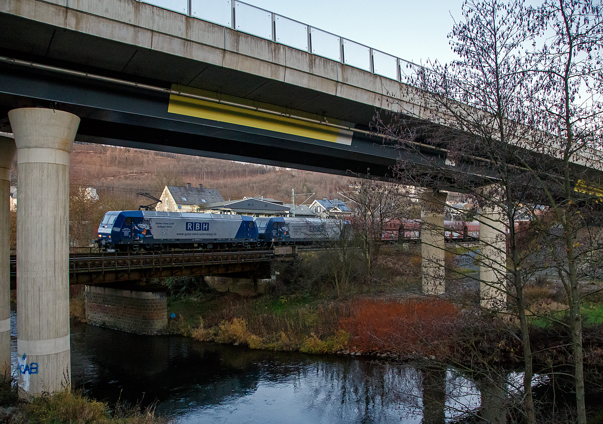 
Nicht gerade die beste Fotostelle in Niederschelden.....
Die RBH 230 (DB 145 071-7) und RHB 210 (DB 145 010-5) ziehen am 18.12.2020 in Doppeltraktion einen Kohlenzug (offene Schüttgutwagen der Gattung Falns) am 18.12.2020 durch Siegen-Niederschelden in Richtung Köln. Beide Loks sind an die RBH Logistics GmbH (Gladbeck) vermietete TRAXX F140 AC der DB Cargo AG.

Vorne die 145 071-7 (91 80 6145 071-7 D-DB) wurde 2000 von Adtranz (ABB Daimler-Benz Transportation GmbH) in Kassel unter der Fabriknummer 33816 gebaut und dahinter die 145 010-5  (91 80 6145 010-5 D-DB) wurde 1997 von Adtranz unter der Fabriknummer 22304 gebaut. Beide TRAXX F140 AC gehören der DB Cargo AG und sind seit 2018 an die RBH Logistics GmbH (Gladbeck) vermietet die sie als RBH 230 und RBH 210 führen, wobei die RBH eine 100%ige Tochter der DB Cargo AG ist.

Die RBH Logistics ist ein Tochterunternehmen der DB Cargo Deutschland AG und die Nachfolgegesellschaft von Werks-, Zechen- und Hafenbahnen im Raum der Bergwerksdirektion Recklinghausen. Durch die verschiedenen Firmenzusammenschlüsse und -aufteilungen ergab sich seit 1913 eine wechselvolle Geschichte. Das heute als Teil des Firmennamens genutzte Akronym RBH stand einige Jahre für die RAG-Bahn- und Hafenbetriebe und wurde beim Verkauf von dieser an die Railion Deutschland im Jahr 2005 beibehalten. Nach damaliger Angabe des neuen Eigentümers stehen die Buchstaben R, B und H nun für die Kernkompetenzen des Unternehmens: Eisenbahnverkehr (Rail), Binnenschifffahrt (Barge) und Hafenumschlag (Harbour).
