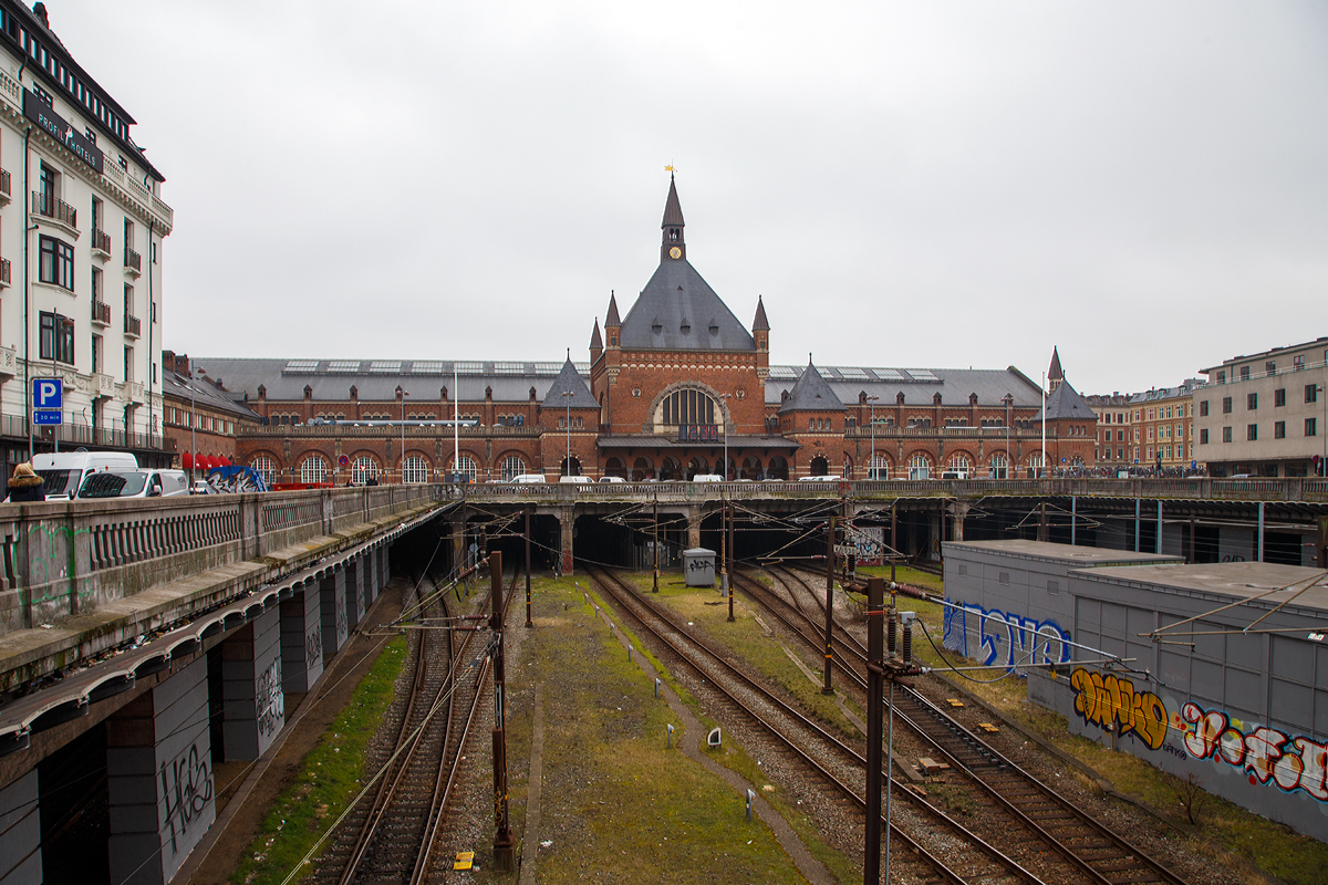 
Nordansicht vom Hauptbahnhof Kopenhagen (dän. Københavns Hovedbanegård) am 20.03.2019.

Københavns Hovedbanegård, abgekürzt København H, ist der Hauptbahnhof von Kopenhagen und wichtigste Fernbahnhof im Streckennetz der Dänischen Staatsbahnen. Er entstand nach einem Entwurf des Architekten Heinrich Wenck und wurde am 1. Dezember 1911 in Betrieb genommen. 

Der heutige Hauptbahnhof hatte zwei Vorgänger-Bahnhöfe an gleicher Stelle. Der erste Bau wurde 1847 errichtet, wobei die Bahnsteiggleise quer zu der heutigen Ausrichtung verliefen. Der zweite Bahnhof wurde als Ersatz für den zu klein gewordenen ersten Bahnhof 1864 eröffnet. Der jetzige Bahnhof war zunächst (wie seine Vorgänger) als reiner Kopfbahnhof angelegt, am 30. November 1911 von König Christian X eingeweiht und am folgenden Tag in Betrieb genommen.

Der heutige Bahnhof befindet sich im Südwesten der Innenstadt im Bereich ehemaliger Wallanlagen am Übergang zum Viertel Vesterbro. Auf der östlichen Seite schließt sich unmittelbar der innerstädtische Vergnügungspark Tivoli an. Gegenüber dem Hauptportal, an der Vesterbrogade, steht die 1797 errichtete Freiheitssäule, die an die Aufhebung der Leibeigenschaft in Dänemark erinnert.

Das Empfangsgebäude des jetzigen Durchgangsbahnhofes befindet sich wie schon zu Beginn nördlich quer zu den Gleisen, die beim heutigen Stand unter dem erhöhten Bahnhofsvorplatz und durch einen Tunnel hindurch in Richtung Norden bzw. Helsingør weitergeführt werden. Dadurch entsteht im Stadtbild weiterhin der Eindruck eines Kopfbahnhofes. Die Tunnelstrecke wird neben den Zügen nach Nord-Seeland auch vom S-tog-System befahren. Die wichtigsten Fernverkehrsstrecken (Öresundverbindung, Vestbanen nach Fredericia, Vogelfluglinie) erreichen den Hauptbahnhof jedoch von Süden. Der Bahnhof hat 13 Bahnsteiggleise, von denen die Gleise 1 bis 8 und 26 für den Regional- und Fernverkehr genutzt werden, die Gleise 9 bis 12 von der S-Bahn Kopenhagen (S-tog).
