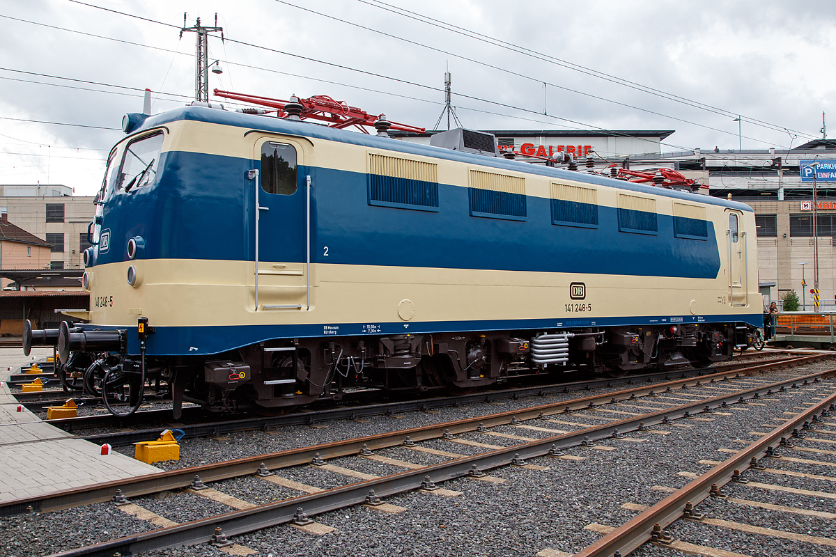 
Nun wieder in der blau/beige Sonderlackierung des  Karlsruher Zuges , diesen trug sie von 1977 bis 2000...........
Die 141 248-5, ex DB E 41 248, wird am 20.08.2016 beim Lokschuppenfest vom Südwestfälischen Eisenbahnmuseums in Siegen vor dem Ringlokschuppen präsentiert. Nach nun nach 16 Jahren in „Verkehrsrot“ wieder  in der Sonderlackierung des  Karlsruher Zuges , so war sie früher auch sehr oft auf der Ruhr-Sieg und der Dill-Strecke zu sehen. Sie war auch die einzige in dieser Versuchslackierung zum Karlsruher Wendezug (grün-beige), diesen trug sie 1977 bis 2000.
 
Die Lok wurde 1963 von Henschel unter der Fabriknummer 30451 gebaut, der elektr. Teil von Brown, Boveri & Cie AG (BBC). Im Jahr 2003 wurde sie z-gestellt, heute ist sie Eigentum vom DB-Museum Nürnberg und eine Leihgabe an das Südwestfälisches Eisembahnmuseum (Bw Siegen).

Von 1977 bis 1995 war der  Knallfrosch“ dem BW Hagen-Eckesey zugeteilt, im Januar 1977 erhielt sie den asymmetrischen S-Bahn-Versuchslack, der der allgemeinen ozeanblau-beigen Farbgebung ähnelt. Die Lok sollte immer mit der gleichen Seite an einem mit blauen Fensterband umgerüsteten Versuchszug der BD Essen aus umgebauten Silberlingwagen für den S-Bahn-Verkehr am Zug hängen, damit Lok und Wagen farblich harmonierten. Dieser Zug, der sogenannte „Karlsruher Zug“, war der Prototyp für die bis heute zahlreich eingesetzten S-Bahn-Züge, gebildet aus Lokomotiven der Baureihen 111 bzw. 143 und drei bis fünf x-Wagen.