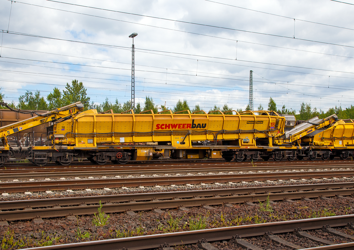 
Plasser & Theurer Materialförder- und Siloeinheit MFS 100 der Schweerbau (Schweres Nebenfahrzeug Nr. 97 19 34 552 57-3) am 17.06.2017 in Koblenz-Lützel.

Die MFS 100 und dienen zum Transport von Schotter, Abraum und Pufferspeicher bei der Bettungsreinigung bzw. Planumsverbesserung. Hauptvorteil ist der kontinuierliche Förder-, Speicher- und Entladevorgang. Eine Zusammenstellung von beliebig vielen MFS-Wagen zu einem Zug mit jeweils gewünschter Speicherkapazität ist möglich. Der Füllvorgang beginnt beim vordersten Wagen (in Arbeitsrichtung), die folgenden Wagen dienen als Förderstraße.

Technische Daten: 
Länge über Puffer 22.900 mm 
Länge inkl. Förderband 26.550 mm
Achszahl 8 (2 Drehgestelle mit je 4 Achsen) 
Drehzapfenabstände: 3.900 mm / 11.200 mm / 3.900 mm
Achsabstand in den Drehgestellen: 1.500 mm 
Laufraddurchmesser: 850 mm
max. Achslast (beladen) 18t 
Eigengewicht: 60 t 
max. zulässige Zuladung 84 t (Streckenklasse D4) 
Motorleistung: 160 kW für Antrieb der Förderbänder 
max. Geschwindigkeit im Zugverband 100 km/h 
max. Fassungsvermögen 68 m³
Bandgeschwindigkeit: Bodenband 0,00 - 0,55 m/s; Übergabeband 0,00 - 1,20 m/s
Förderleistung: 0 – 800 m³/h
