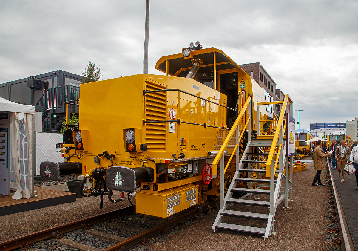 Plasser & Theurer pr�sentierte auf der iaf 2022 in M�nster (hier am 31.05.2022) mit der Plasser BallastMaster 205, ein neues Angebot von Schotterplaniermaschinen der Serie Plasser BallastMaster. Flexible Verteilung und Profilierung. Schotter Verteilen und Profilieren f�r Strecken und Weichen (5 m� Silo).

Die Maschine wurde 2022 von Plasser & Theurer in Linz (A) unter der Fabriknummer 7363 gebaut.

Die Plasser & Theurer Maschinen zur Schotterprofilierung sind die optimalen Werkzeuge f�r die Verteilung und das Planieren des Gleisschotters. Das beinhaltet das Pfl�gen von Bettungsflanke, Randweg und Bettungskrone, unterschiedliche Kehrarbeitsg�nge sowie das Aufnehmen, Speichern und Wiedereinbringen von Schotter.

Die Plasser BallastMaster ist ein neues Angebot bei den Schotterplaniermaschinen und k�nnen variabel aufgebaut werden. Sie passen mit ihrer Leistungsbandbreite zu einer Vielzahl von Gleis- und Weichenstopfmaschinen. Denn nur das optimale Zusammenspiel von Stopfen, Stabilisieren und Profilieren kann die Kosten moderner Gleisdurcharbeitung signifikant senken.

Bei der Entwicklung wurde besonderes Augenmerk auf �konomie und Effizienz f�r die Betreiber gelegt. Aufbau der Maschine und Zusammenstellung der Aggregate richten sich nach dem definierten Anforderungsprofil. 

Die kleinste 2-achsige Ausf�hrung ist auch f�r die Streckenklasse C2 (20 t Achslast) geeignet. Die gr��te 4-achsige Ausf�hrung hat zwei Fahrkabinen mit durchgehender Verkleidung und kann sogar mit dem P&T E�-Antriebssystem betrieben werden.

Die neuen Schotterplaniermaschinen gehen sparsam mit der Ressource Schotter um und speichern �bersch�ssigen Schotter, um ihn an Stellen mit Bedarf wieder einzubringen. Alle Maschinen der neuen Serie sind mit einem integrierten Silo ausgestattet, um Schotterverlagerungen und auch Speicherungen kleiner Mengen von �bersch�ssigem Schotter vornehmen zu k�nnen. Das Spektrum reicht dabei von Speichervolumen mit ca. 5 m� �ber Maschinen mit 7,5 m� bis zu 10 m�. Durch die vielf�ltigen Verstell M�glichkeiten kann Schotter sogar vom Bettungsfu� aufgenommen werden. Die Ausschwenkbegrenzung erm�glicht den gefahrlosen Einsatz ohne Behinderung des Zugverkehres am Nachbargleis.

Neuerungen f�r h�here Effizienz und Wirtschaftlichkeit:
Die zweiteiligen Flankenpfl�ge lassen sich an jede Bettungsflanke anpassen, ohne das Lichtraumprofil eines Nachbargleises zu verletzen, auch nicht beim Aufr�sten der Maschine. Im Bereich der Bettungskrone wird der von den Flankenpfl�gen herangebrachte Schotter �bernommen und weiter verteilt. Im Mittelpflug steuern Leitbleche und verstellbare Pflugschilder exakt die jeweilige Richtung des Schotterflusses. Der Stopfzonenbereich wird dabei optimal verf�llt. Danach entfernt eine Kehranlage liegen gebliebene Schotterk�rner von den Schwellenoberfl�chen. Dieser �bersch�ssige Schotter wird entweder seitlich entladen oder, im Sinne der h�heren Wirtschaftlichkeit, �ber ein F�rderband in den Speichersilo transportiert.

Neue Kehrb�rste f�r alle Schwellentypen:
Mit der neu entwickelten verstellbaren B�rstenwelle k�nnen alle Schwellentypen bearbeitet werden. Holzschwellen und Betonschwellen in Weichen ben�tigen eine gleichf�rmige B�rste, Betonschwellen auf der Strecke dagegen eine abgestufte B�rstenwelle. Bei Spezialschwellen sind auch Zwischenstellungen notwendig. Bisher mussten die kompletten B�rstenwellen je nach Anwendungsfall gewechselt werden, was arbeits- und zeitintensiv war. Mit der neuen Kehrb�rste ist dies nicht mehr erforderlich, es muss auch keine Wechselb�rste mitgef�hrt werden. Die Verstellung der B�rstenwelle erfolgt stufenlos.

Kehranlage mit flexibler Schotterverteilung:
Bisher konnten die Kehranlagen den aufgenommenen Schotter entweder in den Silo oder zu den Flanken verteilen. Mit der neuen Generation ist es m�glich, flexibel zu w�hlen: ein Drittel des Schotters in den Silo und zwei Drittel zu den Flanken oder umgekehrt. Selbstverst�ndlich kann auch weiterhin der gesamte Schotter in den Silo gef�rdert werden.

Steilf�rderband mit mehr Leistung und weniger Staubentwicklung:
Auch das Steilf�rderband zum Silo wurde verbessert. Durch die optimierte Neigung und gerade F�hrung wird die Schotterf�rderung in den Silo erleichtert. Verschiedene Ma�nahmen reduzieren die Staubentwicklung, wie zum Beispiel die bessere Abdichtung und optimierte Verbindung zum B�rstengeh�use.

Schottersilo erh�ht Einsparungspotenzial und Wirtschaftlichkeit:
Durch die Ausstattung mit einem Silo wird vor der Stopfung der vorgelagerte Schotter optimal verteilt, was die Wirtschaftlichkeit der Schotternutzung deutlich erh�ht. Die pr�zise durchgef�hrte Schotterverteilung unserer Schotterplaniermaschinen wirkt sich unmittelbar positiv auf das Arbeitsergebnis und die Stabilit�t der Gleislage aus. Denn nur wenn die eingebrachte Schottermenge auf jedem Gleismeter an die Anforderungen der Gleishebung durch die Stopfmaschine angepasst ist, kann bei der Durcharbeitung ein optimales Ergebnis erreicht werden.

�ber vier einstellbare Schottersch�chte k�nnen die Stopfzonen jederzeit flexibel und punktuell mit dem gespeicherten Schotter eingeschottert werden. Die Anordnung der Sch�chte vor dem Mittelpflug gew�hrleistet die technologisch richtige Arbeitsfolge. Auch eine Einschotterung der Flanken ist direkt aus dem Silo m�glich.

Optimierte Ergonomie in der Kabine und bei der Wartung:
Auch die ger�umigen Arbeitskabinen der Schotterplaniermaschinen konnten weiter optimiert werden. Die Sichtpositionen von den ergonomisch gestalteten Bedienerst�nden auf das Gleis und die Pfl�ge wurden verbessert. Das erleichtert die Arbeit der Maschinisten und steigert Qualit�t und Tempo.

�ber die Wartungsplattformen auf beiden Seiten des Antriebsblocks sind die Hydraulikkomponenten und der Motor leichter zug�nglich. Bei den neuen Maschinen wurde der Motor gegen�ber der bisherigen Einbauposition um 180� gedreht. Das vereinfacht die Wartungszug�nge und vermindert die Ger�uschentwicklung in der Kabine.

TECHNISCHE DATEN der Plasser BallastMaster 205:
Spurweite: 1.435 mm (Normalspur)
Achsanzahl: 2 
L�nge �ber Puffer: 17.640 mm
Achsabstand: 10.000 mm
Eigengewicht: 40 t
Max. Achslast: 20 t
Schottersilo: 5 m�
Wasservorrat f�r Staubniedernebelungsanlage zur Kehreinrichtung: 800 l (optional)
Antriebsleistung: 390 kW
H�chstgeschwindigkeit Eigenfahrt und geschleppt: 100 km/h
Min. Kurvenradius: 150 m
Zul. Streckklasse: C2 oder h�her
Bremse: Ke-GP m7
