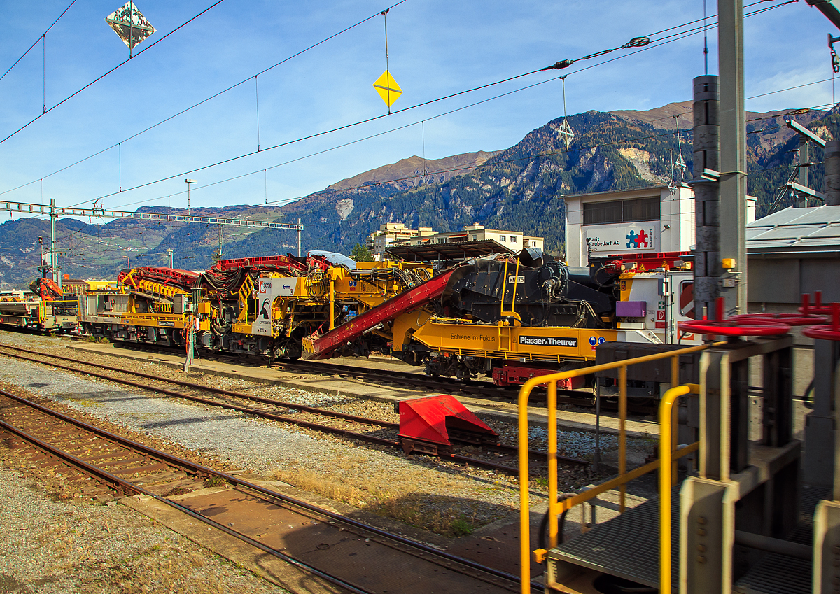 Plasser & Theurer Schotterreinigungsmaschine RM76-SM „CAPRICORN“ (98 78 9 501 561-6 SERSA-CH) der Sersa Maschineller Gleisbau AG steht am 01.11.2019 im Bahnhof Thusis (aufgenommen aus einem Zug heraus). Leider hier nicht ganz komplett im Bild.

Für die Optimierung der Streckenerneuerung im Meterspurbereich bekam die Sersa Maschineller Gleisbau AG (Rhomberg Sersa Rail Group) 2016 die neuen Schotterreinigungsmaschine RM76-SM „CAPRICORN“ von Plasser & Theurer.

Die neue Schotterreinigungsmaschine RM76 CAPRICORN wurde basierend auf der langjährigen Betriebserfahrung der Experten der Sersa Maschineller Gleisbau AG und dem Fachwissen des österreichischen Maschinenherstellers Plasser&Theurer entwickelt und erbaut. Die Maschine ist speziell für den Einsatz im Meterspurbereich konzipiert und trägt den Namen „CAPRICORN“ zu Recht, bewältigt sie doch Steigungen bis zu70 Promille und Kurvenradien bis 45 Meter problemlos, so ist sie auch auf der Berninabahn einsetzbar. Sie windet sich an Felsen entlang und durchquert enge Tunnels bis zum Firn und Eis der Hochalpen.

Bei der Maschinenkonstruktion wurden verschiedene Modifikationen und Innovationen wie die Neuschotterzuführung aus einem angehängten Silowagen, die Planumsglättung und der Einbau von Geotextil realisiert. Zusammen mit der Planier- und Verdichtungsmaschine R20RD ist nun im Meterspurbereich eine moderne und effiziente Maschinenkombination im Einsatz. Alle bisherigen Einsätze verliefen ausnahmslos erfolgreich, bewiesen aber einmal mehr deutlich, dass die Verhältnisse bei den Schweizer Gebirgsbahnen mit jenen bei normalspurigen Bahnen in Europa nicht vergleichbar sind. Sind doch beispielsweise große Steine und alte Fundamente auf Gebirgsstrecken eher die Regel als die Ausnahme. Die Investitionen in die Entwicklung und Realisierung der CAPRICORN zugunsten einer Effizienzsteigerung von Einsätzen im Meterspurbereich sind deshalb gerechtfertigt.

Systembeschreibung
Die Schotterreinigungsmaschine RM76 CAPRICORN fördert mittels einer Kette den Schotter in die Siebanlage. Der gereinigte Schotter wird wieder in das Gleisbett eingebracht. Dieses effiziente Verfahren schont die Umwelt und Ressourcen gleichermaßen. Der verschmutzte Abraum wird auf Altschotterwagen gefördert und abtransportiert. Die RM76 CAPRICORN in Kombination mit dem Portalkransystem MUNGG ermöglicht ganze Streckenerneuerungen (inklusive Gleis- und Schwellenersatz) auch in der Nachtsperre.

Für den Abschluss der Arbeiten kommen Stopf- und Planiermaschinen zum Einsatz.

TECHNISCHE DATEN:
Spurweite: 1.000 mm (Meterspur)
Anzahl angetriebene Achsen: 8
Länge über Puffer: 35.500 mm
Eigengewicht: 124 t
Antriebsleistung: 839 kW	
Höchstgeschwindigkeit Eigenfahrt und geschleppt: 60 km/h
Min. Kurvenradius: 45 m
Bremssystem: Druckluft und Vakuum
Arbeitsgeschwindigkeit 150-180 m/h
Arbeitsleistung typisch: 300 m³/h
Schotterbett (Breite 4 m / Volumen 1,8-2 m³/m)
Aushubbreite minimal: 2.6 m
Aushubbreite maximal: 4.2 m
Schotterreinigung: Sieb mit 3 Decks
Wassersprühanlage: ja

Quelle: Sersa Group AG
