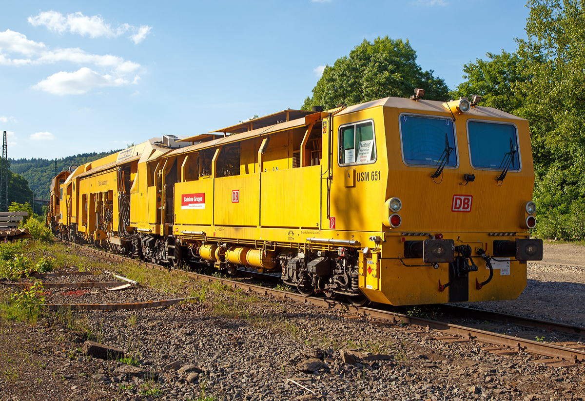 
Plasser & Theurer Universalstopfmaschine UNIMAT 09 - 16 / 4S (Schweres Nebenfahrzeug Nr. 97 43 51 001 17-3)  USM 651  „Yellow Submarine“  der DB Bahnbau Gruppe, abgestellt am 14.06.2017 in Betzdorf/Sieg abgestellt. Ehemals gehörte die Maschine der DB Netz AG, Maschinenpool (Netz Instandhaltung).

Die Universalstopfmaschine mit der internen DB Bezeichnung USM 651 wurde 2002 von Plasser & Theurer in Linz (A) unter der Fabriknummer 3023 gebaut.

Die Universalstopfmaschine Unimat 09-16/4S für Gleise und Weichen verfügt über vier unabhängig voneinander arbeitende Stopfaggregate mit insgesamt 16 Stopfpickeln. Bei der Gleisdurcharbeitung ist kontinuierliches Fahren und zyklisches Stopfen bis weit in den Weichenbereich hinein möglich

Funktionsmerkmale der USM Unimat 09-16/4S: 
- die vier Stopfaggregate können gedreht, einzeln seitlich verschoben und somit vor jedem Stopfgang optimal positioniert werden
- für das Stopfen von Langschwellen werden die außen liegenden Stopfaggregate mit horizontalen Teleskop-Führungssäulen seitlich ausgefahren (Vierstrang-Stopfung)
- kontinuierliches Fahren und zyklisches Stopfen bis weit in den Weichenbereich hinein
- Durcharbeitung von Weichen erfolgt mit Dreistrang-Hebung und Vierstrang-Stopfung
- eine automatisch arbeitende Zusatzeinrichtung gewährleistet die Hebung des dritten Stranges
- Richtungslaser zum Verlängern der Messbasis in der Geraden
- 6-Kanal-Schreiberanlage zur Dokumentation der Gleißlage und Arbeitsqualität 
- Vibrationsverdichter
- automatischer Leitcomputer ALC mit EM-SAT Datenverarbeitung
- automatische Toleranz-Überwachung für Arbeitsqualität der Maschine
- Korrektursteuerung für Höhe, Längshöhe, Richtung, Überhöhung

TECHNISCHE DATEN:
EBA-Nummer: EBA 00 A 11 003
Spurweite: 1.435 mm (Normalspur)
Anzahl der Achsen: 8 davon 4 angetrieben
Achsfolge: 2' 2'+Bo' Bo' 
Länge über Puffer:  33.140 mm
Drehzapfenabstände: 10.000 mm / 3.500 mm / 14.000 mm
Achsabstand im Drehgestell: 1.800 mm
Raddurchmesser (neu): 920 mm
Eigengewicht: 131.000 kg
Nutzlast: - t
Zul. Anhängelast: 60 t
Leistung: ca. 500 kW 
Zur Mitfahrt zugel. Personenzahl: 6
Kleister befahrbarer Gleisbogen: R = 120 m (Arbeitsradius  min.  150 m)
Zugelassen für Streckenklasse: C2 und höher
Höchstgeschwindigkeit: 100 km
Bremse: KE-GP mZ K
Bremsgewichte: G 102 t / P 108 t

Arbeitsleistung bei Durcharbeitung im Gleis:  600 m/h
Arbeitsleistung bei Durcharbeitung von Weichen : 1 /h