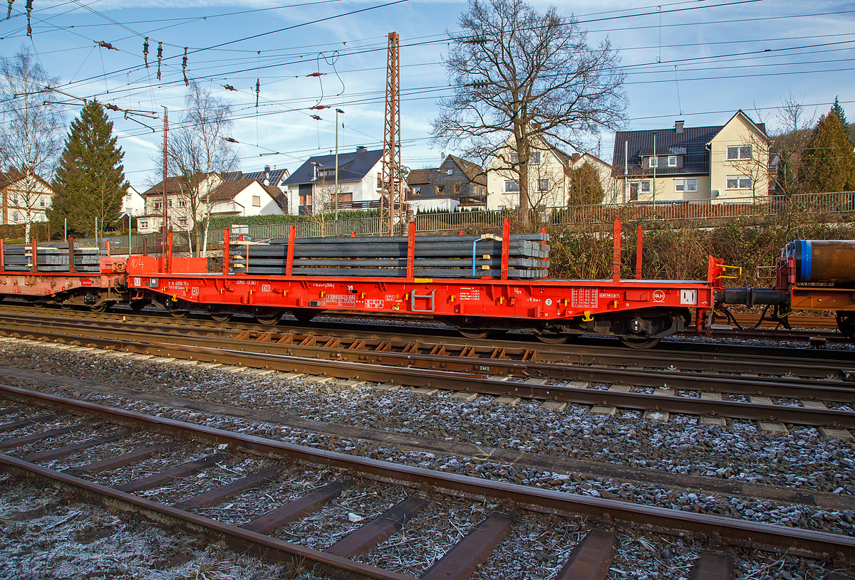 Sechsachsiger Drehgestell-Flachwagen, mit Rungen, Stirnwandklappen und klappbaren Ladeschwellen, jedoch ohne Seitenwandklappen, Nummer 31 80 4858 111-6 D-DB, der Gattung Samms 489.1, beladen mit Stahlkn�ppel (Vierkantstangen), am 22.12.2021 im Zugverband bei einer Zugdurchfahrt in Kreuztal.

Zusammen mit Stahlkunden entwickelt die DB Schenker im Jahre 2007 einen neuen Flachwagen, der auf die Bed�rfnisse der Branche noch besser eingeht. Gebaut wurden sie von dem slowakischen Hersteller Tatravagonka a.s. Poprad.

Der Wagen dient mit aufgeklappten Ladeschwellen zur Bef�rderung von schweren Walzprofilen und anderen sperrigen G�tern. Mit eingeklappten Ladeschwellen, also mit ebener Ladeebene, eignet er sich auch zum Transport schwerer Kettenfahrzeuge. F�r das Be- und Entladen solcher Fahrzeuge sind befahrbare Stirnwandklappen vorhanden.
Die Wagenbr�cke ist eine in Rahmenbauweise ausgef�hrte Schwei�konstruktion, deren Hauptbauteile aus S355J2 (St 52) bestehen. Die Hauptbelastungen werden von den �u�eren Langtr�gern aufgenommen. Das Kopfst�ck und Untergestell sind so ausgebildet, dass sp�ter ohne gro�e �nderungen die AK eingebaut werden kann.
Der Fu�boden besteht aus Kiefernbohlen mit den Abmessungen 70 x 200 mm; er kann eine Radlast von 5,0 t aufnehmen. Im Fu�boden sind 6 geteilte klappbare Ladeschwellen eingebaut, ebenso 6 Zurrpunkte je L�ngsseite. An den Au�enlangtr�gern sind 26 Binde�sen angebracht.

Das Fahrzeug hat auf jeder L�ngsseite 6 Einsteckrungen und 6 zus�tzliche Rungensch�chte, wodurch eine variable Platzierung der Rungen erm�glicht wird (anders als bei den Vorg�nger-Modellen). An jeder Stirnseite gibt es je 2 versenkbare Rungen (Fallrungen). Die Stirnw�nde sind umklappbar.

Die Tragf�higkeit konnte im Vergleich zu anderen Wagen der Bauart Samms auf 104 Tonnen gesteigert werden, weshalb bis zu 20 Prozent Wagenresourcen eingespart und die Transportkette optimiert werden kann. Durch den Einsatz der Kunststoff-Bremssohle (Cosind 810) f�hrt der Wagen l�rmreduziert.

TECHNISCHE DATEN:
Gattung: Samms 489.1 (Gattungskennzahl 4858)
Spurweite: 1.435 mm (Normalspur)
L�nge �ber Puffer: 16.400 mm
Drehzapfenabstand: 9.150 mm
Radsatzstand in den Drehgestellen: 2 x 1.700 mm = 3.400 mm
Raddurchmesser: 920 mm (neu)
Drehgestell-Typ: BA 714.3
Ladel�nge: 15.000 mm
Ladebreite: 2.630 mm (zwischen den Rungen)
Fu�bodenh�he �ber SO: 1.300 mm
Ladefl�che: 46 m�
Eigengewicht: 31.000 kg
Zuladung bei Lastgrenze S: 74,0 t (ab Streckenklasse D2)
Zuladung auf DB Netz bei Streckenklasse CE/D: 89 t (max.100 km/h)
Max. Zuladung: 104 t
Max. Geschwindigkeit: 100 km/h (beladen) / 120 km/h (leer)
Kleinster Gleisbogenhalbmesser: 75 m
Bauart der Bremse: KE-GP-A (K) max. 88 t
Bremssohle: Cosid 810
Verwendungsf�higkeit: TEN-GE
