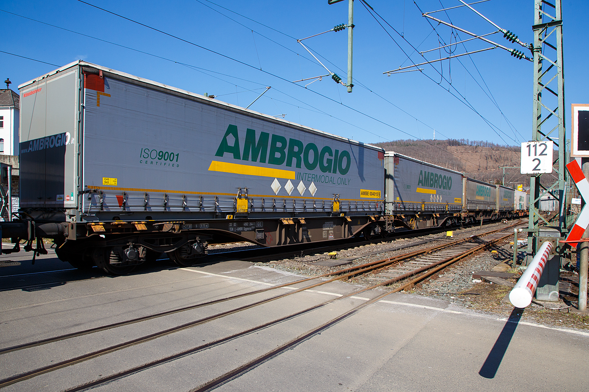 Sechsachsiger Drehgestell-Gelenk-Containertragwagen, 33 83 4962 264-1 I-AMBR, der Gattung Sggmrss 579.0, der Ambrogio Trasporti S.p.A. (Vinovo , Italien), am 24.03.2021 im Zugverband bei der Durchfahrt in Niederschelden an der Siegstrecke (KBS 460) in Richtung Siegen.

TECHNISCHE DATEN:
Spurweite: 1.435 mm
L�nge �ber Puffer: 29.590 mm
Drehzapfenabstand: 2 x 11.995 mm
Achsabstand in den Drehgestellen: 1.800 mm
Laufraddurchmesser: 920 mm (neu)
Eigengewicht: 29.000 kg
Max. Zuladung bei Lastgrenze S: 106,0 t (ab Streckenklasse D)
Max. Zuladung bei Lastgrenze SS: 91,0 t (ab Streckenklasse C)
Max. Geschwindigkeit: 100 km/h (Lastgrenze SS und leer 120 km/h)
Kleinster befahrbarer Gleisbogen: R 75 m 
Bremse: 2 x DK-GP-A (K)
Bremssohle: Jurid 816 M
Feststellbremse: Ja 
Verwendungsf�higkeit: TEN GE