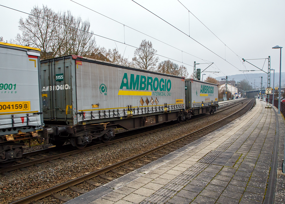 Sechsachsiger Drehgestell-Gelenk-Containertragwageneinheit 90´, 33 83 4954 823-4 P I-AMBR der Gattung Sggmrs 90` Privatwagen der Ambrogio Trasporti S.p.A. am 14.01.2022, beladen mit 45` Wechselbrücken der Ambrogio, im Zugverband bei der Durchfahrt im Bf Kirchen (Sieg) an der Siegstrecke (KBS 460) in Richtung Köln. Die Ambrogio besitzt eine eigene Flotte von 380 privaten 6-achsigen Gelenktragwagen 90 `.

Diese Gelenkwagen mit sechs Radsätzen sind für den Transport von Großcontainern und Wechselbehältern vorgesehen. Auf den Außenlangträger des Wagens befinden sich für jede vorgesehene Ladeposition feste und klappbare Aufsetzzapfen zum Festlegen der Ladungseinheiten (gemäß UIC- Merkblatt 592-1 und 2) in verschiedenen Kombinationen.
