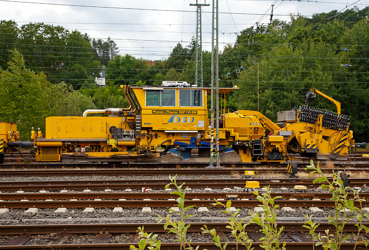 
Seitenansicht von der Plasser & Theurer Schotterverteil- und Planiermaschine SSP 110 SW (Schweres Nebenfahrzeug Nr. 97 16 46 519 18 - 3) der DGU (Deutsche Gleisbau Union), abgestellt am 24.06.2018 in Betzdorf/Sieg.

Der Schotterpflug wurde 2008 unter der Masch.-Nr. 847 von Plasser & Theurer gebaut.

Schotterpflüge werden vor oder nach dem Stopfen des Gleises eingesetzt.
Die Maschinen bewirken eine optimale Schotterverteilung und Formen das Profil des Schotterbettes. Dies ist notwendig für den Seitenwiederstand des Schotterbettes. Der Schotterpflug SSP 110 SW ist mit einem Schotterbunker von 5 m³ ausgestattet. Der Schotterpflug SSP 110 SW kann sowohl für Gleis- als auch Weichenschotterplanierarbeiten eingesetzt werden.

Technische Daten:
Eigengewicht: 44 t
Länge über Puffer: 17.220 mm 
Achsanzahl: 2 (große Räder) 
Achsabstand: 8.100 mm
Motorleistung: 400 kW
Fahrgeschwindigkeit mit Eigenantrieb: 100 km/h
Kleinster befahrbarer Radius: 120 m
zul. Streckenklasse: D4 oder höher
