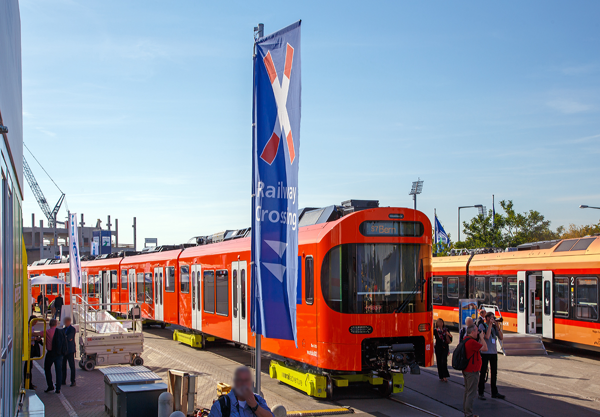 
Stadler Rail pr�sentierte auf der InnoTrans 2018 (hier 18.09.2018) den neuen Worbla-Zug Be 4/10 f�r die RBS (Regionalverkehr Bern-Solothurn),  hier in Form von dem RBS Be 4/10 Worbla 02.  Bis 2020 sollen alle Mandarinli durch die Worblas bei der RBS ersetzt werden.
Der Triebzug steht hier auf Rollb�cke der RailAdventure GmbH („Loco Buggies“).

RBS hat im Juni 2016 bei Stadler in Bussnang 14 vierteilige S-Bahn-Z�ge vom Typ Be 4/10 Worbla (Elektrischer Niederflurtriebzug) f�r die Linie S7 bestellt. Die vierteiligen elektrischen Meterspurz�ge weisen 2 Triebk�pfe am Ende und 3 Jakobs-Laufdrehgestelle als Verbindung zwischen den 4 Wagenk�sten auf. Die Z�ge sind f�r eine maximale Geschwindigkeit von 100 km/h ausgelegt. Sie sind auf der gesamten L�nge von 60 Metern durchgehend begehbar, was die Verteilung der Reisenden im Zug verbessert und das Sicherheitsgef�hl erh�ht. Die Triebz�ge sind klimatisiert und erf�llen die Anforderungen des Behinderten-Gleichstellungsgesetzes. Niederflureinstiege und Schiebetritte zwischen Zug und Bahnsteig erleichtern den Eintritt. Modernste Technologien wie die voll redundante Traktionsanlage inklusive redundanter Leittechnik garantieren eine hohe betriebliche Verf�gbarkeit und tiefe Life-Cycle-Kosten.

Technische Mekmale:
- Niederflurwagen in Alu-Leichtbauweise
- Luftgefederte Trieb- und Jakobslaufdrehgestelle
- Optimierte Motorleistung entsprechend des Einsatzes als Stadtbahn-Triebzug f�r den Betrieb auf Kurzstrecken
- Redundante Antriebsausr�stung (Antriebsstromrichter) in den Endwagen f�r hohe Ausfallsicherheit
- Acht Einstiegst�ren f�r schnellen Fahrgastwechse
- Niederflureintritte an allen T�ren
- T�r-Leuchtmelder (Countdown)
- T�rsensor f�r �handsfree�-Eintritt
- �bersichtliche Plattformen
- Durchgehend begehbar
- Indirekte Beleuchtung
- Gro�z�gige Multifunktionsabteile
- Klimaanlage

TECHNISCHE DATEN:
Bezeichnung: Be 4/10
Name: Worbla
Anzahl Fahrzeuge (geplant): 14
Spurweite: 1.000 mm (Meterspur)
Achsanordnung: Bo‘2‘2‘2‘Bo‘
L�nge �ber Kupplung: 60.000 mm
Fahrzeugbreite: 2.650 mm
Fahrzeugh�he: 3.980 mm
Achsabstand in Drehgestell: 2.000 mm (Triebdrehgestell) / 2.150 mm (Laufdrehgestell)
Trieb- und Laufraddurchmesser: 770 mm (neu)
H�chstgeschwindigkeit: 100 km/h
Max. Leistung am Rad: 4 x 350 kW = 1.400 kW
Anfahrzugskraft: 120 kN (140 kN m�glich)
Anfahrbeschleunigung: 1.0m/s� (1.2m/s� m�glich)
Sitzpl�tze: 130
Stehpl�tze: max. 380
Fu�bodenh�he: 400 mm am Einstieg / 1.000 mm Hochflur
Einstiegbreite: 1 400 mm
Speisespannung: 1.250 V DC
