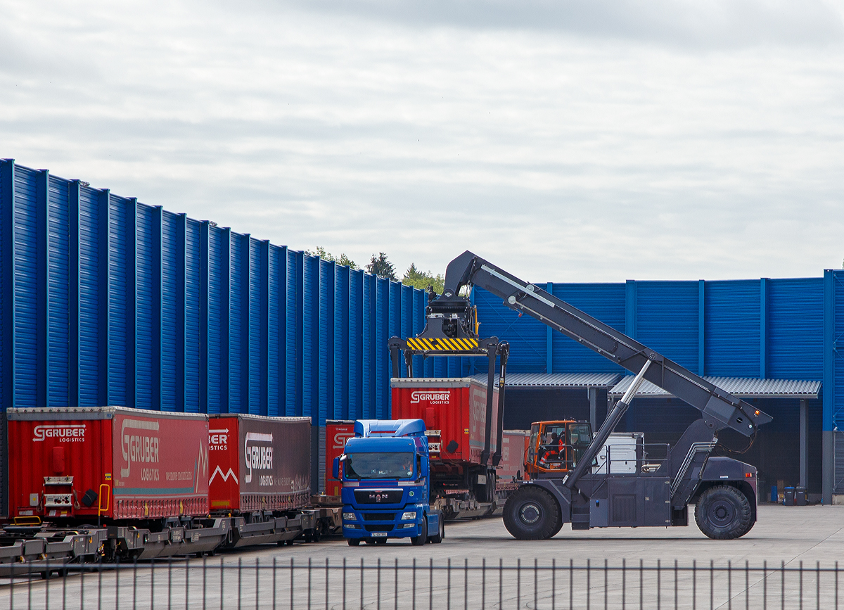 
Südwestfalen Container-Terminal GmbH (SWCT), Kreuztal Ubf, den 31.05.2019:
Die Entladung der Gelenk-Taschenwagen der Gattung Sdggmrs (Typ T3000e).  Die Sattelauflieger (Sattelanhängern) werden nach und nach mittels Reachstacker bzw. Greifstapler aus den Gelenk-Taschenwagen gehoben und sofort an die Sattelzugmaschine angehangen.
