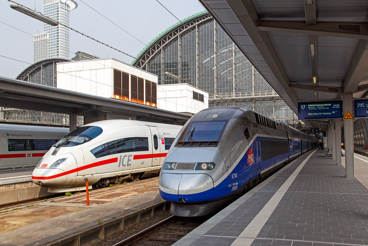 
Unser TGV Euroduplex (2N2) 4714 ist am 24.03.2014 im Hauptbahnhof Frankfurt am Main am Gleis 17, als TGV 9580 / TGV 9581 (Frankfurt am Main Main Hbf - Strasbourg  - Lyon - Marseille St-Charles), bereits bereitgestellt (zuvor fuhr er die Verbindung Paris – Frankfurt). 

Nebenan auf Gleis 18 steht der eingefahrene ICE 3M (Baureihe 406) Tz 4607 „Hannover“, welcher die Zulassungen für Belgien und die Niederlande hat. Auf Gleis 19 steht der ICE 3MF (Baureihe 406F) Tz 4683 „Limburg an der Lahn“, ex Tz 4606, dieser hat die Zulassungen für Frankreich und die Niederlande.