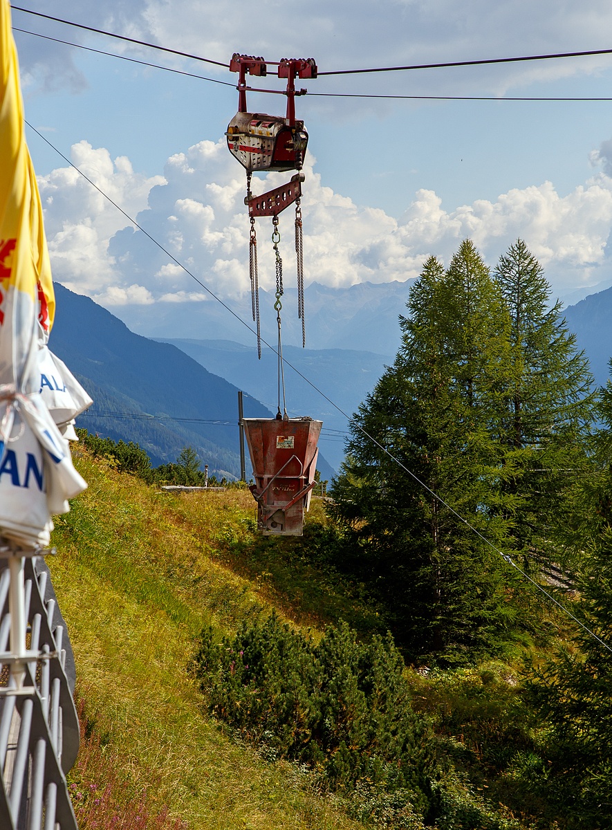Unterhalb Alp Grüm werden die Alp Grüm der Berninabahn erneuert, daher gibt es eine Materialseilbahn von Alp Grüm hinab zu den Galerien, hier am 06.09.2021. So wird oben in Alp Grüm der Beton gemischt und dann mit der Seilbahn hinab gefahren. 

Die hier verwendete Bahn ist vom italienischen Seilbringungs-Spezialisten Seik (Truden). Der verwendete Wagen ist ein Seilkran vom Typ SFM 30/60.  In dem Seilkran befindet sich ein Verbrennungsmotor der das Hubwerk antreibt (dieser läuft nur bei der Hubbewegen) um wie hier den Betonkübel anzuheben und später wieder abzusenken. Die Hubkraft beträgt im Einzelzug 3t oder wie hier im Doppelzug mit dem Waagbalken 6t. Das Gesamtgewicht beträgt ca. 1t. Die Winde für das Zugseil kann nach Belieben (Bergseite – Talseite) platziert werden.