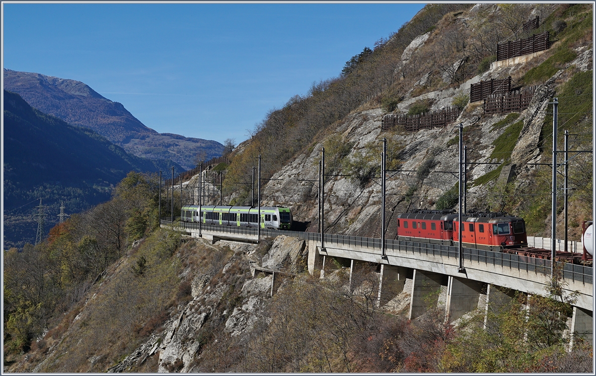 Viel Verkehr auf der Lötschberg Südrampe in der Nähre von Lalden: Während eine  Re 10/10  mit einem Güterzug bergwärts fährt, kommt von Lalden ein  Lötschberger  auf der Fahrt nach Brig entgegen. 
25. Okt. 2017