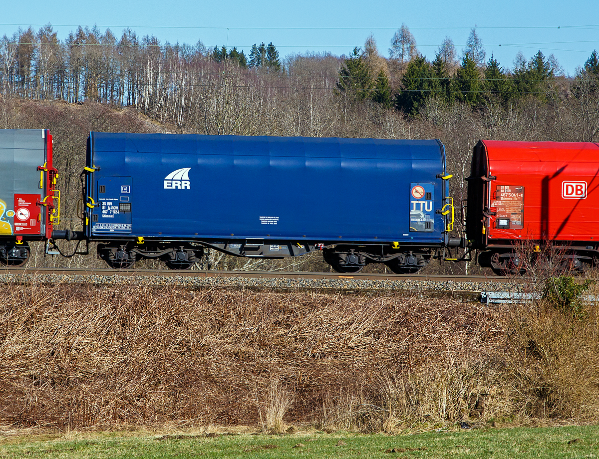 Vierachsiger Drehgestell-Flachwagen mit verschiebbarem Planenverdeck und Lademulden f�r Coiltransporte, 35 81 4677 172-2 A-RCW, der Gattung Shimmns-ttu, eingestellt durch die Rail Cargo Wagon - Austria GmbH, jedoch mit Werbung auf Plane der ERR - European Rail Rent GmbH, am 02.03.2022 im Zugverband bei der Zugdurchfahrt bei Rudersdorf (Kr. Siegen).

Diese Wagen sind speziell f�r den Transport witterungsempfindlicher Blechrollen (Coils) bestimmt. Er besitzt feste Stirnw�nde, 5 fest im Untergestell eingebaute Lademulden. Die Wagenabdeckung erfolgt mit einer PVC-beschichteten Gewebeplane, die auf 11 Rohrrahmen aufliegt. �ber Laufwagen ist das Planendach in Wagenl�ngsrichtung verschiebbar. Die Verriegelung des Planendaches an den Stirnw�nden erfolgt �ber eine 4-Punkt-Zentralverriegelung, die sowohl vom Erdboden als auch von der Rampe aus bedient werden kann. Das Planenverdeck l�sst sich an einem Wagenende so weit zusammenschieben, dass ca. 2/3 der Ladefl�che zur Beladung freigegeben wird. Hierdurch ist eine einfache Beladung des Wagens sowohl von oben als auch von der Seite aus m�glich. 

TECHNISCHE DATEN:
Spurweite: 1.435 mm
Achsanzahl: 4 (in 2 Drehgestelle)
L�nge �ber Puffer: 12.040 mm
L�nge der Ladefl�che: 10.800 mm
Drehzapfenabstand: 7.000 mm
Achsabstand im Drehgestell: 1.800 mm
Eigengewicht: 21.547 kg
H�chstgeschwindigkeit:  100  km/h (beladen) / 120 km/h (leer)
Maximales Ladegewicht: 68,4 t (Streckenklasse D4)
Kleinster bef. Gleisbogenradius: 35 m
Bauart der Bremse: KE-GP-A (K), max. 58 t
Intern. Verwendungsf�higkeit: RIV