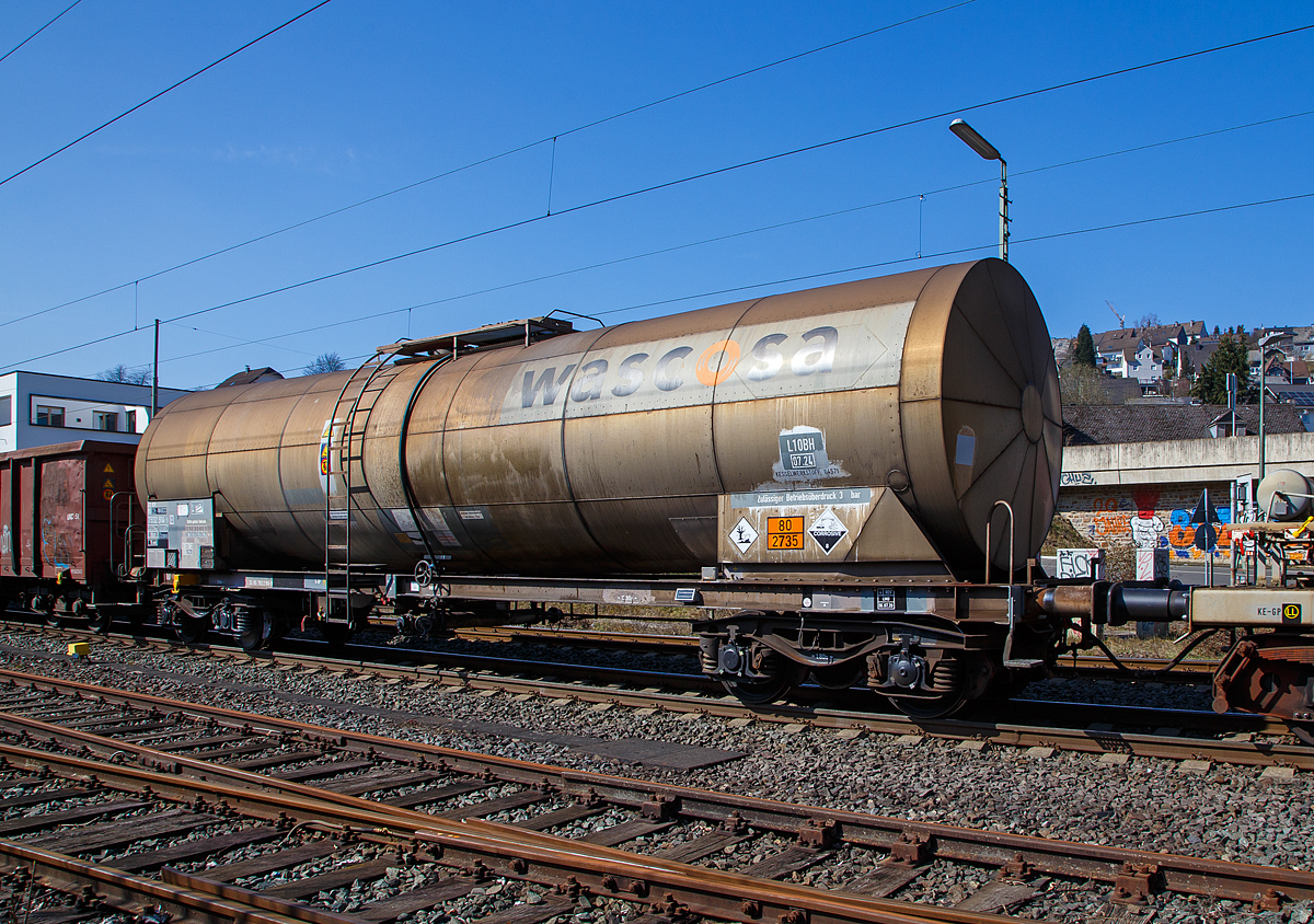 Vierachsiger Drehgestell-Kesselwagen 37 85 7932 914-9  CH-WASCO, der Gattung Zacens, der WASCOSA AG (Luzern), bei der Fahrt im Zugverbund am 24.03.2021 bei der Zugdurchfahrt in Niederschelden (Sieg), hier passiert er gerade den B� 343 (Km 112,183 der Siegstrecke KBS 460). 

Die Gefahrgutkennzeichnung 80/2735 zeigt an es handelt sich um fl�ssig und �tzende Amine oder um  fl�ssig und �tzende Polyamine.

TECHNISCHE DATEN (gem. Anschriften) :
Spurweite: 1.435 mm
Achsanzahl: 4 (in 2 Drehgestelle)
L�nge �ber Puffer: 15.940 mm
Drehzapfenabstand: 10.900 mm
Achsabstand im Drehgestell: 1.800 mm
Laufraddurchmesser:  920 mm (neu) 
Eigengewicht: ca. 24.520 kg
Tankinhalt: 70.000 l 
Max. Ladegewicht: 65,4 t (ab Streckenklasse D)
H�chstgeschwindigkeit: 100 km/h (beladen) / 120 km/h (leer)
Bremse: O-GP
Tankcode: L10BH
L= Tank f�r Stoffe in fl�ssigem Zustand (fl�ssige Stoffe oder feste Stoffe, die in geschmolzenem Zustand zur Bef�rderung aufgegeben werden)
10= zutreffender Mindestpr�fdruck in bar
B = Tank mit Boden�ffnungen mit 3 Verschl�ssen f�r das Bef�llen oder Entleeren 
H = luftdicht verschlossener Tank
Max. Betriebsdruck: 3,0 bar
Kesselwerkstoff: 1.4571 (Edelstahl V4A)
Intern. Verwendungsf�higkeit:  RIV