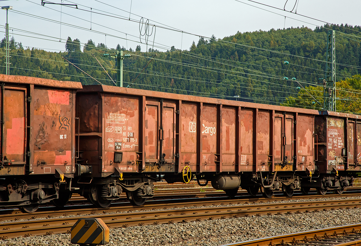 Vierachsiger offener Drehgestell-G�terwagen 31 80 5377 779-9, der Gattung Eanos-x 055, der DB Cargo AG am 03.09.2012 im Zugverband bei einer Zugdurchfahrt in Betzdorf (Sieg).

Im Jahre 1997 mietet DB Cargo f�r sechs Jahre 300 Eanos-x 055 bei der Ahaus-Alst�tter Eisenbahn (AAE). Diese Wagen werden von der AAE bei Vag�nka Poprad/SK beschafft und - da der Vertrag vor Baubeginn geschlossen wurde - im DB Cargo-Design abgeliefert. In den Abmessungen und technischen Daten entsprechen die Wagen haupts�chlich den Eanos-x 052. Sie haben jedoch ein geringf�gig h�heres Eigengewicht und somit um 0,5 Tonnen geringere Lastgrenzen. 

Die Wagen besitzen je Seite nur eine Doppelfl�gelt�r, die eigentlich lediglich der Begehung dient, da die Wagen fast ausschlie�lich durch Kippen oder mittels Krane (Magnet oder Greifer) entladen werden. Er dient vorzugsweise dem Transport von witterungsunempfindlichen Sch�tt- und St�ckg�tern (wie Kohle, Briketts, Schrott, Erze, Steine und Erden). Das Untergestell ist eine Schwei�konstruktion aus Walzprofilen in den Materialg�ten St 37 und St 52 und ist Rahmenbauweise ausgef�hrt.

Der Fu�boden besteht aus 6 mm dicken Blechen. An den Au�enseiten des Wagenkastens sind 32 Binde�sen, am Obergurt 20 offene Haken und im Wageninnern in einer H�he von 200 mm �ber FO 16 Zurr�sen angeordnet. Der G�terwagen ist f�r die Entladung �ber eine Seitenkippanlage geeignet.

TECHNISCHE DATEN:
Spurweite: 1.435 mm (Normalspur)
Achsanzahl: 4 in zwei Drehgestellen
L�nge �ber Puffer: 15.740 mm
Drehzapfenabstand: 10.700 mm
Achsabstand im Drehgestell: 1.800 mm
Drehgestell-Bauart: Y 25 Lss
Ladel�nge: 14.500 mm
Ladebreite:  2.720 mm
Ladeh�he: 2.100 mm
Ladefl�che: 39,4 m�
Laderaum:  82,5 m�
T�r�ffnung: 2 St�ck 1.800 � 1.800 mm
H�chstgeschwindigkeit: 100 km/h (beladen) / 120 km/h (leer)
Maximales Ladegewicht: 65 t (ab Streckenklasse D)
Eigengewicht: 24.100 kg
Kleinster bef. Gleisbogenradius: R 35 m
Bremse: Ch-SP-A (Charmilles-Bremse)
Handbremse: Ja
Intern. Verwendungsf�higkeit: RIV
