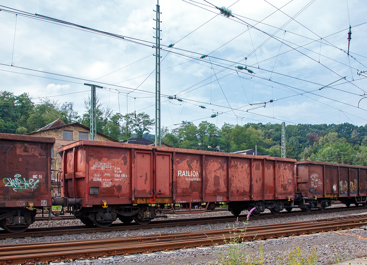 
Vierachsiger offener Güterwagen der Gattung Enos-x 075 (aus ex Eaos 106), 31 80 5368 595-0 D-DB der DB Cargo am 13.08.2020 bei einer Zugdurchfahrt in Betzdorf (Sieg) im Zugverband.

Der Wagen dient in erster Linie für die Beförderung von Schüttgütern und Schrott und ist ein Umbauwagen auf Basis der BA Eaos 106.
Das Untergestell ist unter Verwendung von S235J2 (St 37) in Profilbauweise und geschweißten Blechen ausgeführt. Es ist für eine Radsatzlast von 20 t berechnet. Die Verkleidungsbleche für die Seitenwände sind 4 mm dick aus S355J2 und die der Türen 8 mm dick und aus S355J2 (St 52) gefertigt. Das obere Saumeisen ist durchgehend. Die Stirnwände sind aus in verstärkter Ausführung mit Stirnwandsäulen aus IP 140, Oberrahmen aus Blech 10 mm, Verstärkung aus U200 und Stirnwand aus 8 mm Blech gefertigt. Der Fußboden besteht aus 8 mm dicken Blech aus S355J2.

Die Wagen haben nur noch zwei diagonal angeordnete zweiflüglige Türen. Auf Grund ihres Zustandes beim Umbau können diese entweder links oder rechts angeordnet sein.

Nach Ablauf der 25-jährigen Regel-Einsatzzeit stehen für die noch vorhandenen knapp 2.800 offenen Drehgestell-Wagen der Gattung Eaos 106 ab 2003 Vollaufarbeitungen zum Weiterbetrieb an, die nach einem Umbau die Bezeichnung Eaos-x 075 erhalten. Bei der Hauptuntersuchung (G4.0) im Werk Eberswalde erhielten die Wagen zumeist komplett neue Stirnwände mit U200-Profilen, wie zuvor schon bei den Eanos-x 059 angewandt. Die jeweils rechten Türöffnungen je Seitenwand werden verschlossen und Stahlfußböden eingebaut. Zum Schutz der Bremsumstellungen wurden unter dem Wagenboden stabile Schutzbügel angebracht, die sich in ähnlicher Form auch schon bei den Eanos-x 052, 055 und 059 vor allem im Schrottverkehr bewährt hatten.

TECHNISCHE DATEN:
Spurweite: 1.435 mm (Nornalspur)
Achsanzahl: 4 in zwei Drehgestellen
Länge über Puffer: 14.040 mm
Drehzapfenabstand: 9.000 mm
Achsabstand im Drehgestell: 1.800 mm
Drehgestell-Bauart: Y 25 Cs – 621
Ladelänge: 12.792 mm
Ladebreite:  2.760 mm
Ladehöhe: 2.020 mm
Ladefläche: 35,3 m²
Laderaum:  72 m³
Türöffnung (B × H): 1.800 × 1.800 mm
Höchstgeschwindigkeit: 100 km/h (beladen) / 120 km/h (leer)
Maximales Ladegewicht: 57 t (ab Streckenklasse C)
Eigengewicht: 22.700 kg
Kleinster bef. Gleisbogenradius: R 35 m
Bremse: KE-GP
Handbremse: nein (Wagen mit Handbr. sind 250 mm länger)
Verwendungsfähigkeit: RIV
