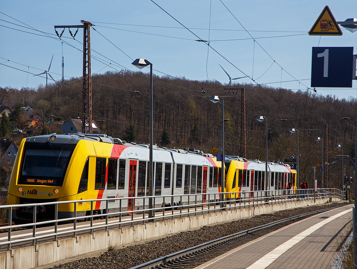 Zwei gekuppelte Dieseltriebzüge vom Typ Alstom Coradia LINT 41 der neuen Generation / neue Kopfform, der HLB (Hessische Landesbahn GmbH), haben am 11.04.2022, als RB 95  Sieg-Dill-Bahn  (Dillenburg – Siegen) den Hp Rudersdorf (Kr. Siegen) erreicht. Vorne der VT 505 (95 80 1648 105-2 D-HEB / 95 80 1648 605-1 D-HEB) und dahinter der VT 504 (95 80 1648 104-5 D-HEB / 95 80 1648 604-4 D-HEB).

Der Triebfahrzeugführer hat die Türen verriegelt, ist ausgestiegen und weist diese unvernünftigen Menschen zurecht bzw. erklärt ihnen was hätte passieren können. Der Grund war, als das Dieseltriebzug-Zwillingspaar einfuhr war die Schranke zwischen  Bahnsteig 1 und 2 bereits geschlossen. Der Zug auf Gleis 2 ist nicht das Problem, aber wenn die Schranke geschlossen ist dann kommt bald ein Zug auf Gleis 1 durch, hier war es DB 185 161-7 die kurz nachdem die unvernünftigen Menschen die geschlossene Schranke ignoriert hatten, auf Gleis durchrauschte (die Höchstgeschwindigkeit beträgt hier 90 km/h). Nicht auszudenken was passiert wäre, wenn sie etwas früher gekommen wäre. 

Der Triebfahrzeugführer hätte sicherlich mit seinem Zug am Bahnsteig gewartet bis die Schranke wieder offen gewesen wäre und die Fahrgäste gefahrlos eingestiegen wären. Denn er war sehr zeitig mit dem Zug eingefahren.
