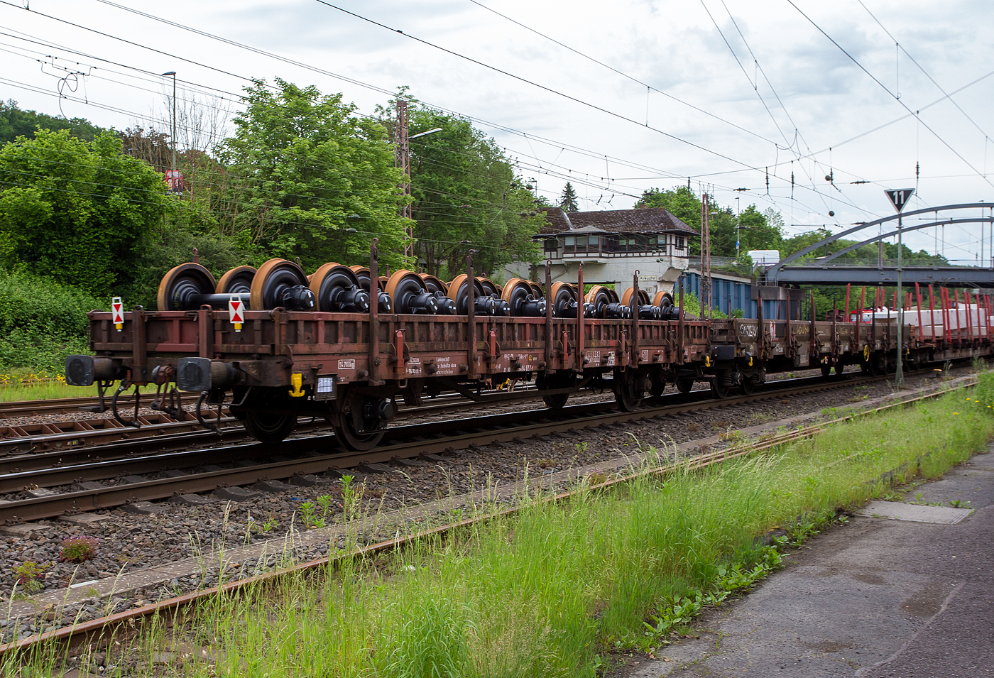 2-achsiger Flachwagen (Niederbordwagen) mit Seiten- und Stirnwandklappen sowie Seiten- und Stirnwandrungen, zudem mit Ladestell für Radsätze ohne Bremsscheiben, 21 80 340 4 027-7 D-DB der Gattung Kkks-t 447, am 21 Mai 2024 beladen mit Radsätzen im Zugverband bei der Zugdurchfahrt in Kreuztal.

Diese Wagen beschaffte die DR 1969/70 beim VEB Waggonbau Niesky, als Ks 3301, zum 01.01.1994 gelangen noch 267 Wagen zur DB AG, die sie in Ks 447 umzeichnete. 

Die Deutsche Bahn AG hat zwischen 2000 und 2002 in ihrem DB Werk Eberswalde (ehem. RAW Eberswalde) bis zu 50 Kkks-t 447 (Nummern ab 3404 000) mit Aufnahmen für Radsätze der Normalbauart (ohne Bremsscheiben) und mindestens 25 Kkks-t 447 (Nummern ab 3404 100) mit Aufnahmen für Radsätze mit Bremsscheiben hergerichtet. Bis 2002 waren somit insgesamt 75 Wagen hergerichtet. Dieser Wagen mit der Nummer 3404 027-7 ist also, wie man auch sieht, für Radsätze ohne Bremsscheiben vorgesehen.

Der Wagenkasten besteht aus 12 stählernen Seiten- und 2 stählernen Stirnborden mit 12 austauschbaren Seitenwanddrehrungen und 4 austauschbaren Stirnwandsteckrungen. Die Borde sind so ausgelegt, dass im abgeklappten Zustand ein unbehindertes Befahren des Wagens von Seiten- und Kopframpen aus möglich ist. Der Wagenboden besteht aus 70 mm dicken Holzbohlen. Bei abgeklappten Endseitenborden ist der Güterwagen nicht profilfrei.

TECHNISCHE DATEN des Wagens:
Spurweite: 1.435 mm (Normalspur)
Achsanzahl: 2
Länge über Puffer: 14.230 mm
Achsabstand: 8.000 mm
Ladelänge zwischen den Stirnwänden: 12.520 mm
Ladebreite: 2.780 mm
Ladefläche: 34,6 m²
Bordwandhöhe: 450 mm
Rungenhöhe: 1.290 mm
Fußbodenhöhe über SOK: 1.245 mm
Höchstgeschwindigkeit: 100 km/h (beladen) / 120 km/h (leer)
Eigengewicht: 17.700 kg
max. Zuladung: 23 t (ab Streckenklasse C)
Kleinster bef. Gleisbogenradius: 35 m
Bauart der Bremse: KE-GP (LL)
Bremssohle: IP 116
Handbremse: nein
Intern. Verwendungsfähigkeit: RIV

Bedeutung der Gattung Kkks-t:
K = Flachwagen in Regelbauart mit zwei unabhängigen Radsätzen
kk = höchste Lastgrenze 20 t bis unter 2
s = lauffähig bis 100 km/h
t = mit Ladestell für Radsätze
447 = Bauartnummer