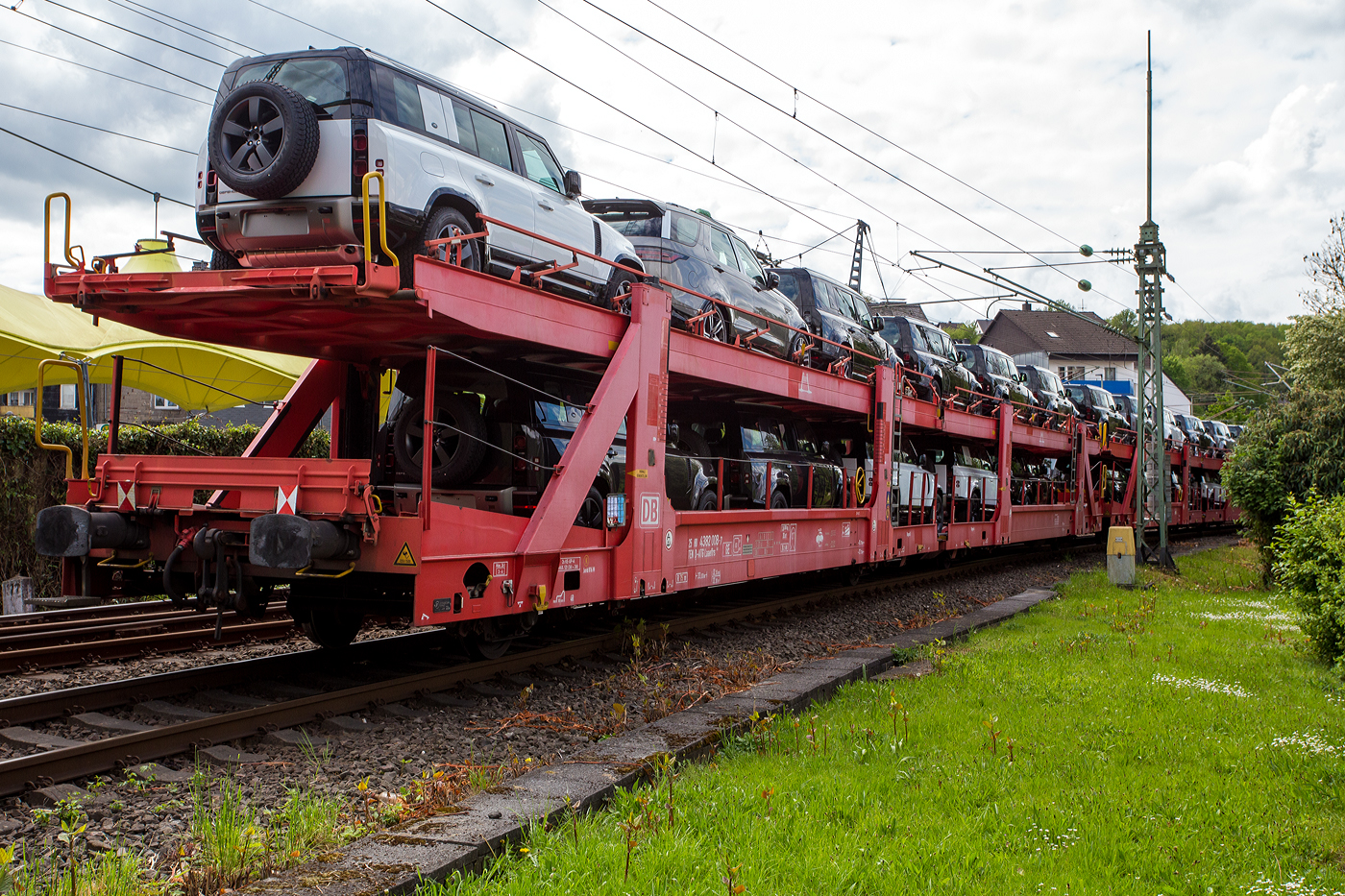 2 x 2 achsiger offener Doppelstock-Autotransportwagen (Wageneinheit) 25 80 4382 008-7 D-ATG der Gattung Laaeffrs 561 der DB Cargo Logistics GmbH (ex ATG Autotransportlogistic GmbH), beladen mit SUV´s, am 05 Mai 2024 im Zugverband (Zugschuss) bei der Durchfahrt in Betzdorf (Sieg).

Die Wagen der Gattung Laaeffrs 561 sind im Rahmen von dem Projekt „Innovativer Güterwagen“ neuentwickelte Wagen. Es ist auch die Antwort auf den sich verändernden Automobilmarkt, auf dem zunehmend größere und schwerere Fahrzeuge gefragt sind (SUV). So eignen sich diese Wagen insbesondere für den europaweiten Transport von großvolumigen Pkws, SUVs und Vans, auch bei kleineren Lichtraumprofilen. Mit der hohen Lastgrenze von 35,5 Tonnen ist der Transport von besonders schweren Fahrzeugen möglich.

Damit sowohl ein typenreiner Transport als auch eine Mischverladung in den unterschiedlichen Lademaßen möglich ist, kann die obere Ladeebene hinsichtlich der Transportstellungen stufenlos eingestellt werden. Flexible Elemente der unteren Ladeebene sowie eine spezielle Geometrie der oberen Ladeebene dienen zusätzlich der effizienteren Ausnutzung des Laderaums bei besonders hohen Pkw.

Zur Ladungssicherung befinden sich auf der oberen und unteren Ladeebene jeweils 32 Radvorleger. Eine Besonderheit ist auch die erhöhte Arbeitssicherheit durch das Klappgeländer auf der oberen Ladeebene.

Die Vorteile auf einen Blick:
– Zweigliedriger, doppelstöckiger Autotransportwagen
– Hohe Lastgrenze
– Große Durchfahrhöhe
– Obere Ladeebene flexibel einstellbar
– Untere Ladeebene mit verstellbaren Elementen für eine höhere Auslastung
– Verringerte Gesamthöhe durch besondere Geometrie der oberen Ladeebene
– Klappbare Absturzsicherung auf der oberen Ladeebene

TECHNISCHE DATEN:
Gattung: Laaeffrs 561
Baujahr: ab 2018
Hersteller (u.a.): Tatravagónka a.s. Poprad (Slowakei)
Spurweite: 1.435 mm
Anzahl der Achsen: 4
Länge über Puffer : 33.000 mm
Ladelänge : 32.080 mm (unten) / 32.550 mm (oben)
Ladebreite : 2.950 mm (unten) / 2.794 mm (oben)
Wagenhöhe: 3.500 mm
Achsabstände: 10.700 / 5.900 / 10.700 mm
Laufraddurchmesser (neu): äußere 760 mm und mittlere 730 mm
Typ der Radsätze: BA 375 
Höchstgeschwindigkeit: 100 km/h (beladen) / 120 km/h (leer)
Eigengewicht: 36.500 kg
Nutzlast: 35,5 t ab Streckenklasse B (max. 18 t pro Ebene)
Max. Gewicht je Pkw: 2.800 kg
Kleinster befahrb. Gleisbogenhalbmesser: R 75 m
Höhe des Klappgeländers: 1.100 mm 
Bremse: KNORR KE-GP-A (K)
Bremssohle: Jurid 816M
Intern. Verwendungsfähigkeit: TEN-GE
