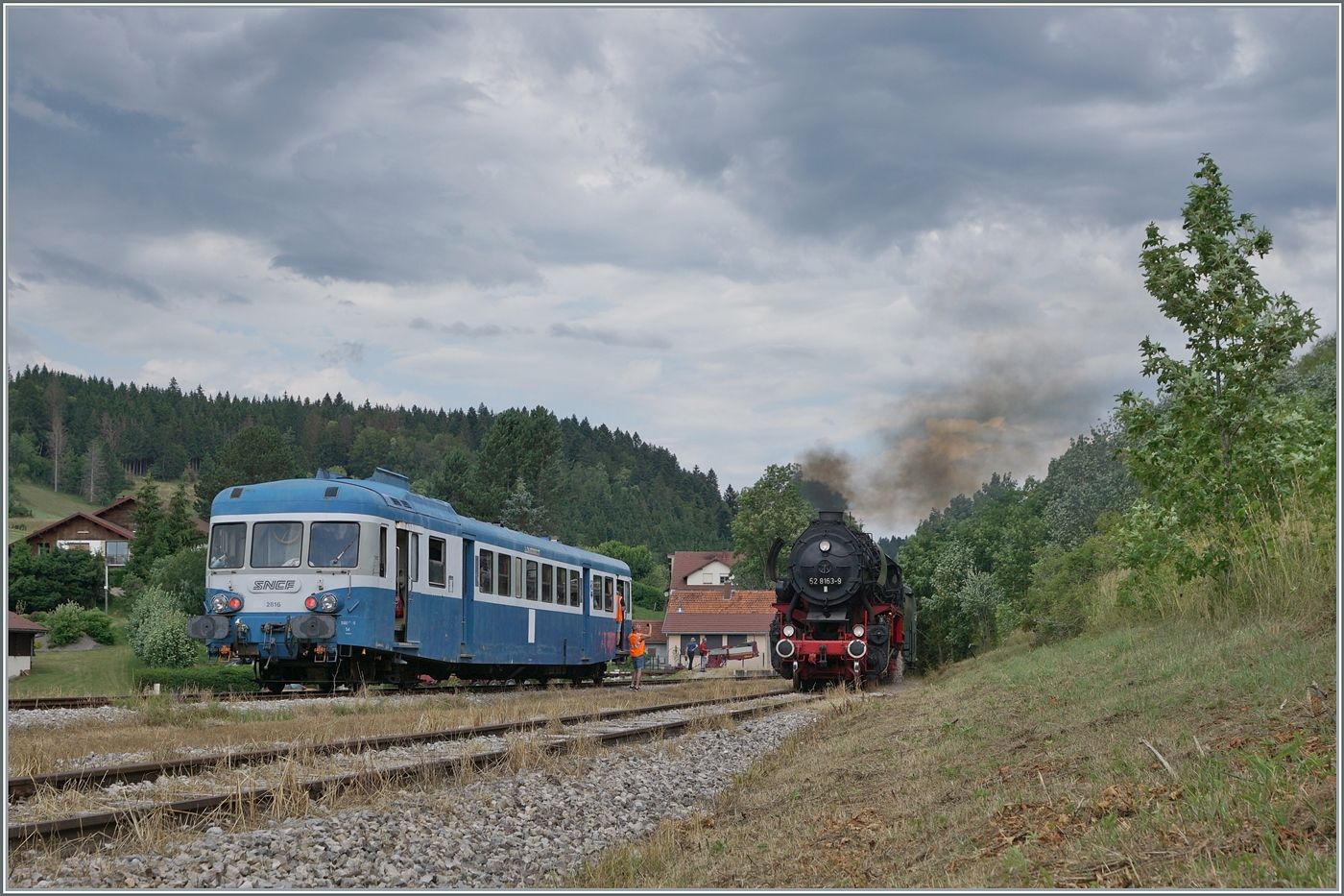 30 ANS CONI'FER /30 Jahre Coni'Fer - So viel Verkehr gab es wohl hier seit gut 110 Jahren nicht mehr! Der X 2816 der Association l'autorail X2800 du Haut-Doubs wartet im mir bis anhin unbekannten Kreuzungsbahnhof der Coni'Fer von Le Touillon auf den von der 52 8163-9 geführten Gegenzug.

15. Juli 2023
